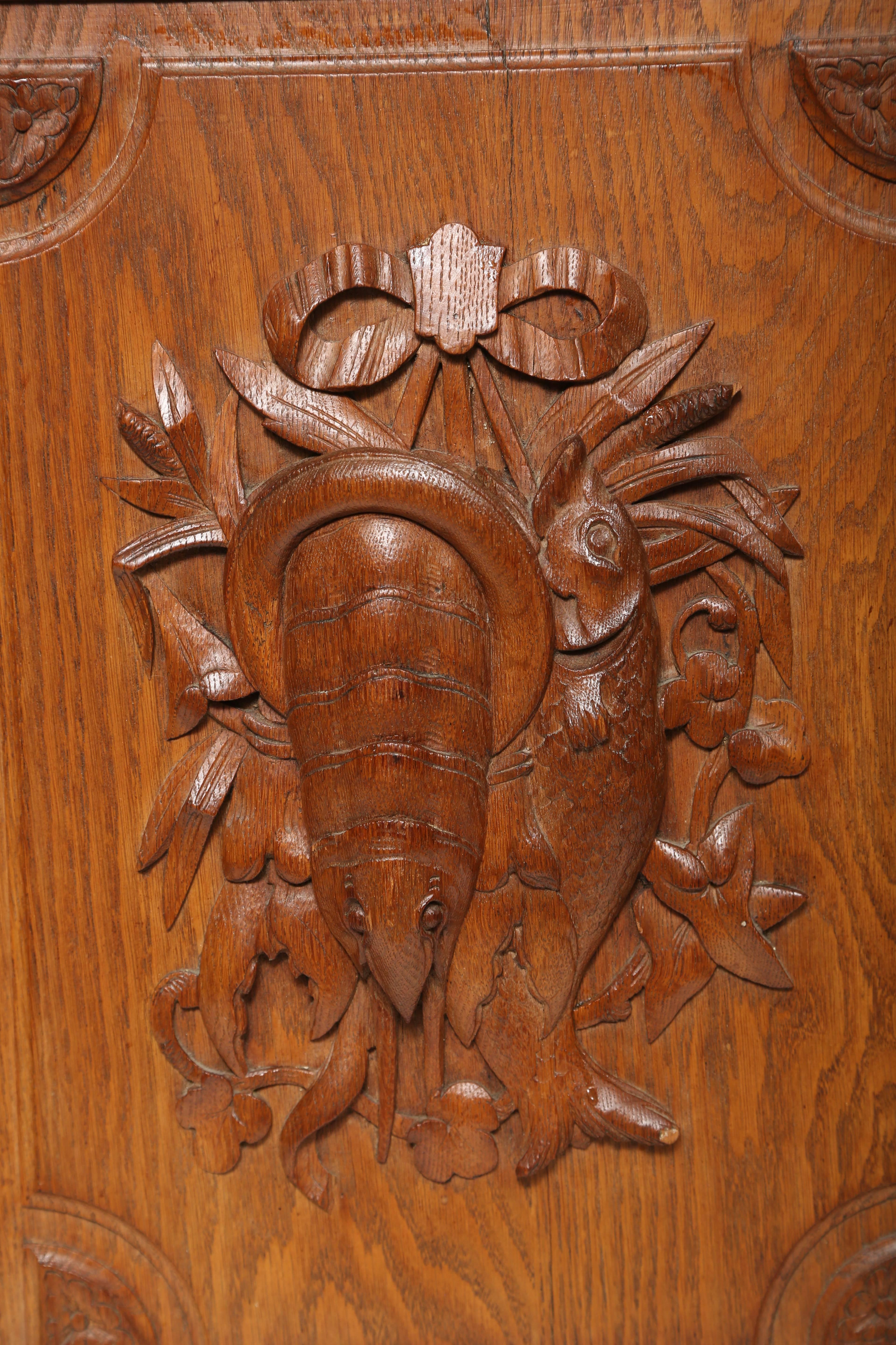 Deeply hand-carved wood fishing plaque referred to as a trophy panel.  It depicts  a lobster and a fish tied up with a bow on a fielded panel.