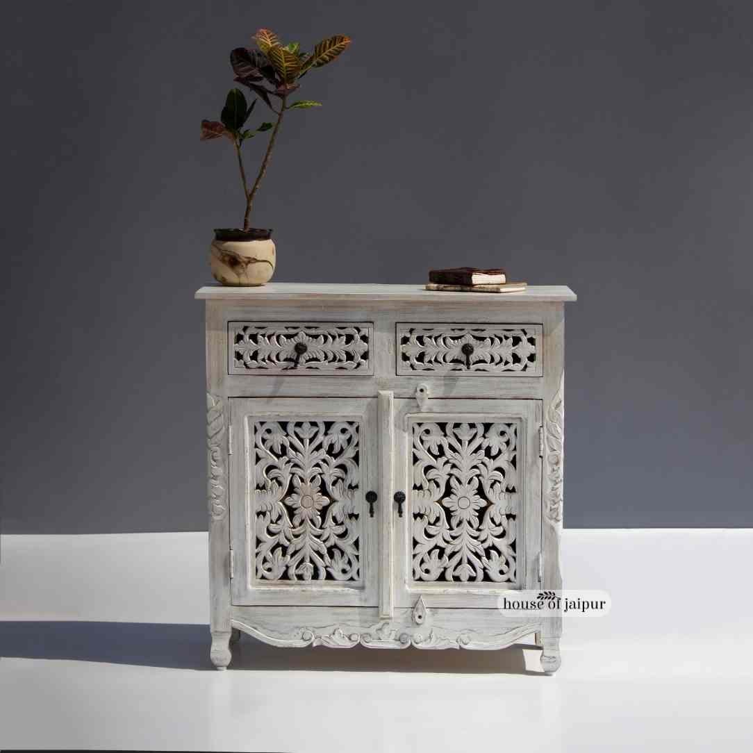 Cette magnifique armoire en bois sculptée à la main apporte une touche de charme vintage et de savoir-faire artisanal à n'importe quelle pièce. La façade présente des sculptures florales complexes, chaque motif étant façonné à la main et mis en