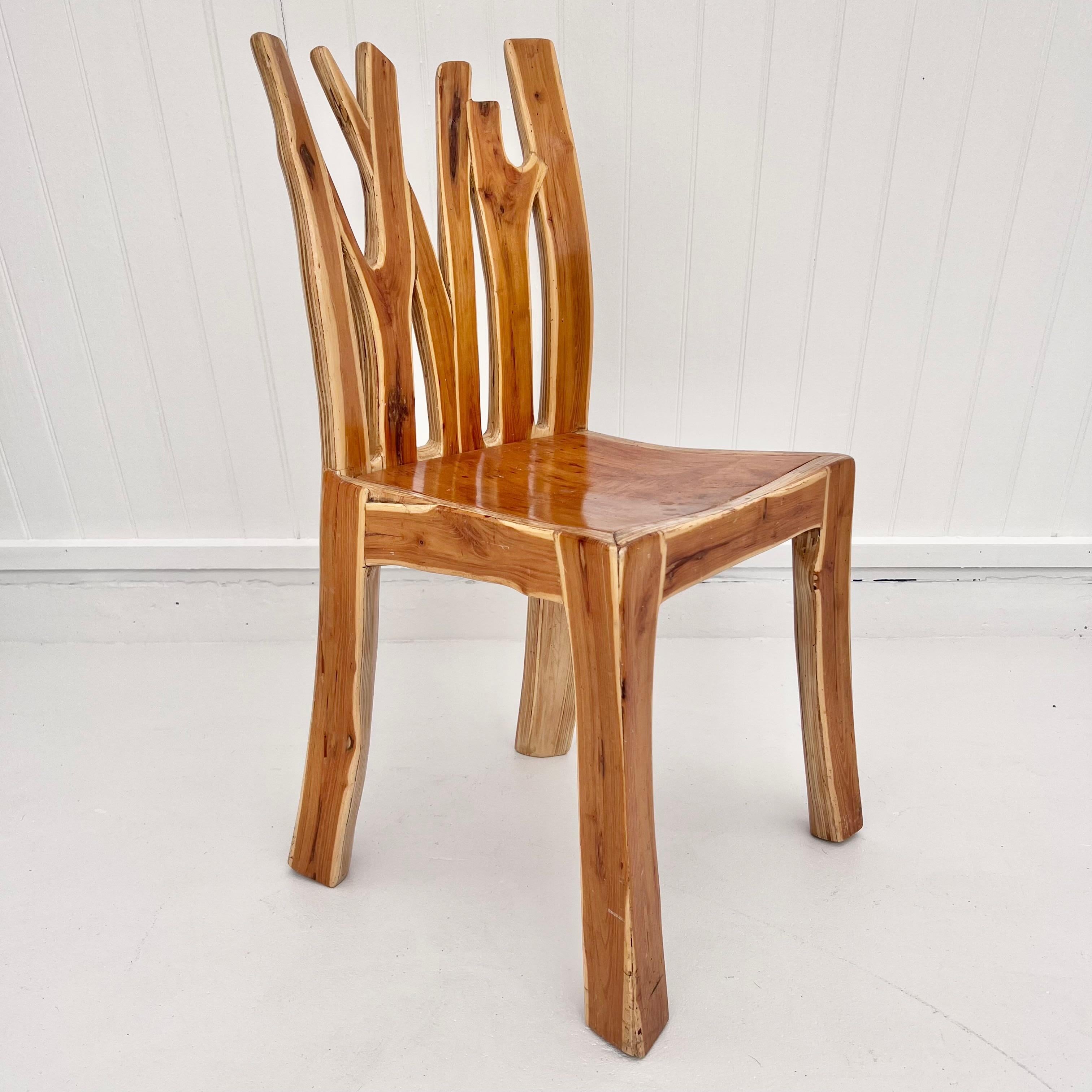 Hand carved sculptural accent chair that features a unique live edge on the legs and backrest which resembles branches. The frame of this chair is made of a thick plywood with the outer layer made of a sheet of solid wood giving it a beautiful and