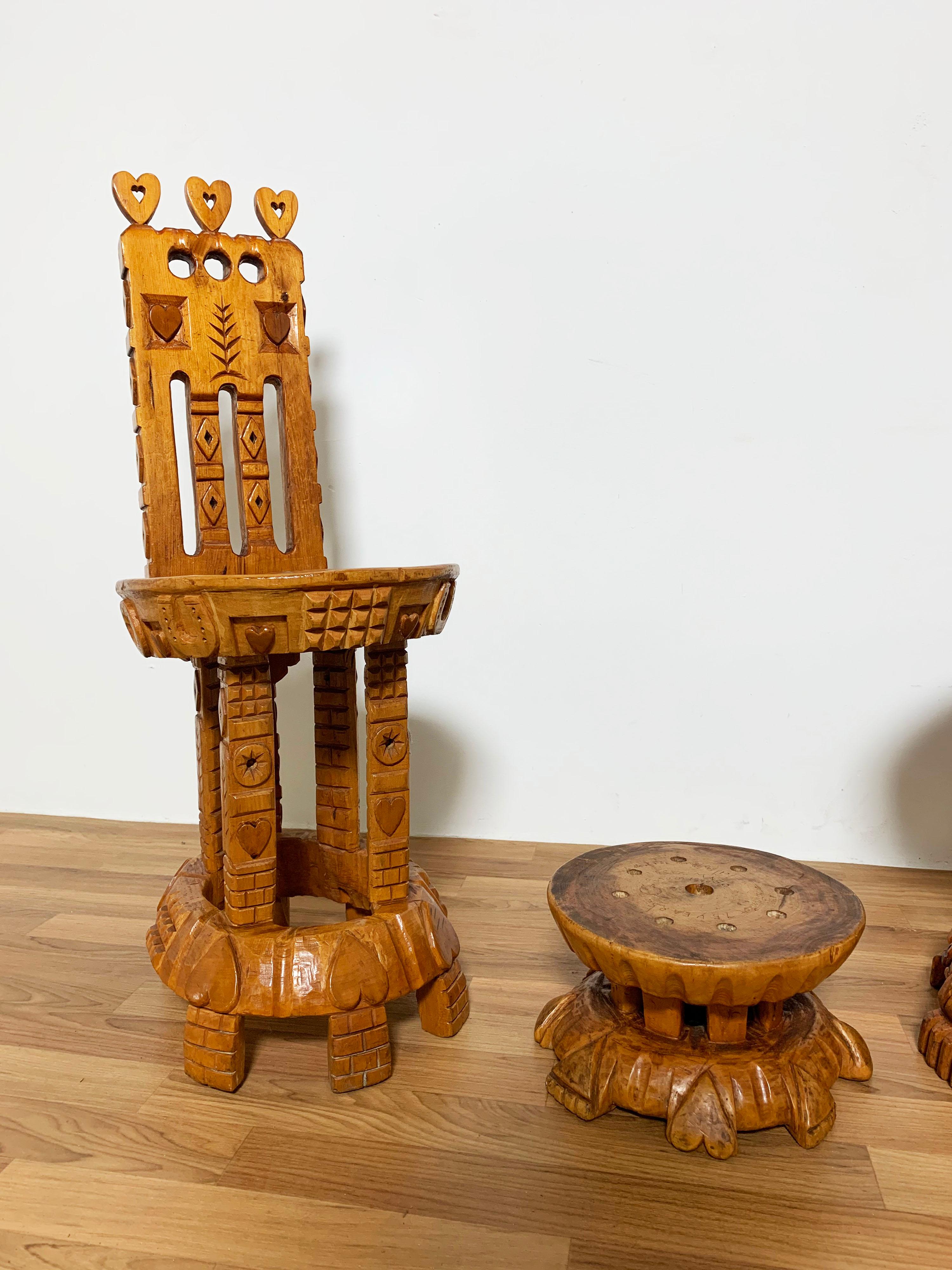Pair of folk art hand carved chairs with footstool by Joseph Deveau (1901-1999), made by the artist for himself and his wife. 

Deveau crafted his furniture each evening over several decades during the mid 20th century, All of his pieces were