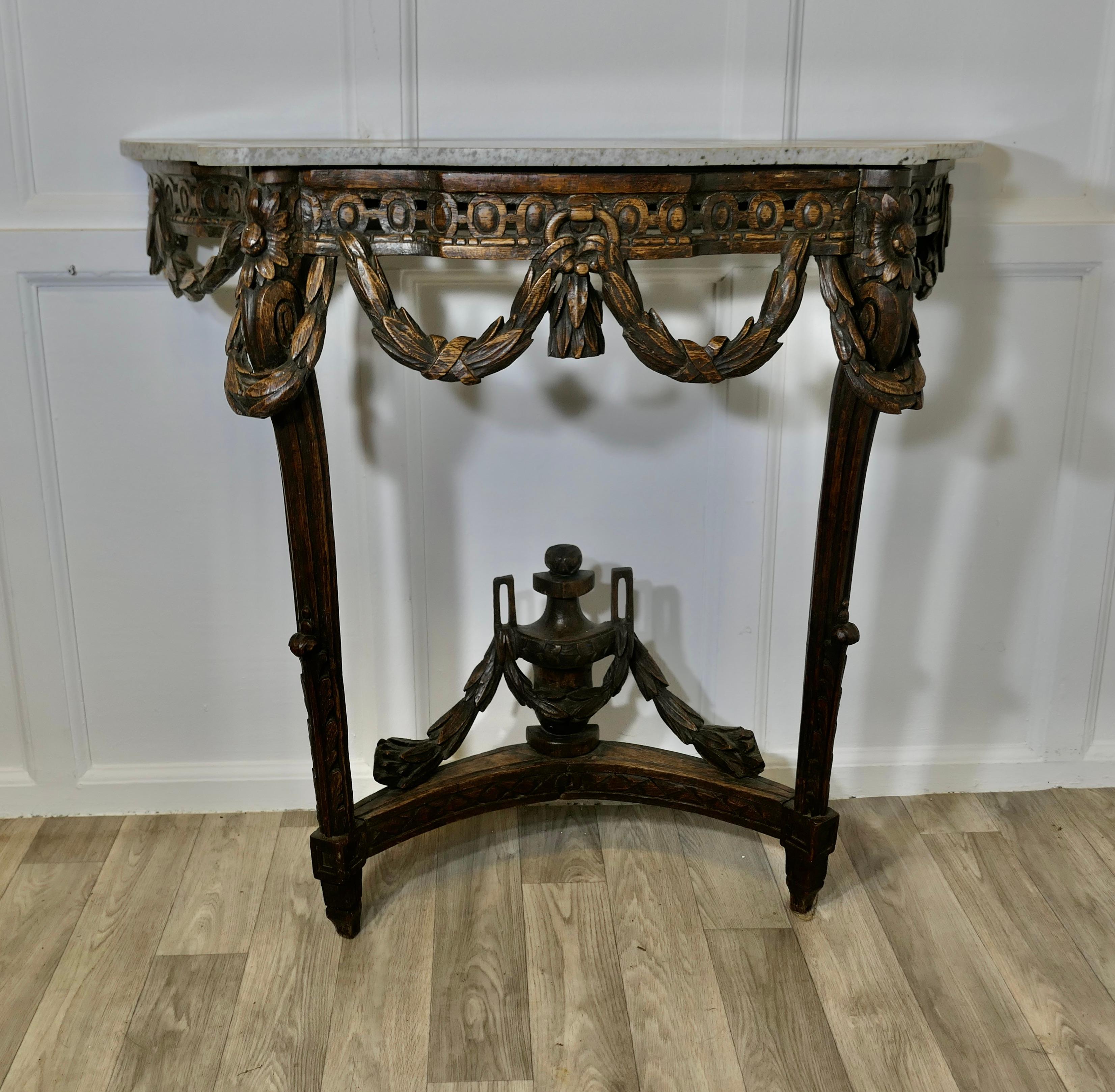 Hand Carved French Console Table, with Granite Top

This is a very unusual piece, the table has a waxed finish, it is hand carved in stained walnut with an Urn and Swag decoration, it has a scalloped shape with a smooth edge to the white granite top