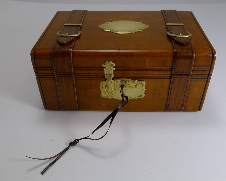 A highly sought-after miniature jewelry trunk, perfect for either a lady or gentleman.

Made from fruitwood, it is intricately hand-carved in the from of a trunk including straps to the sides and straps to the top, trimmed in polished
