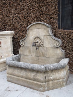 Hand Carved French Limestone Wall Fountain with Shell Motif and Sloped Shoulders