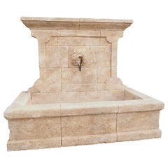 Fontana da parete in pietra calcarea francese intagliata a mano con beccuccio in ferro battuto proveniente dalla Provenza