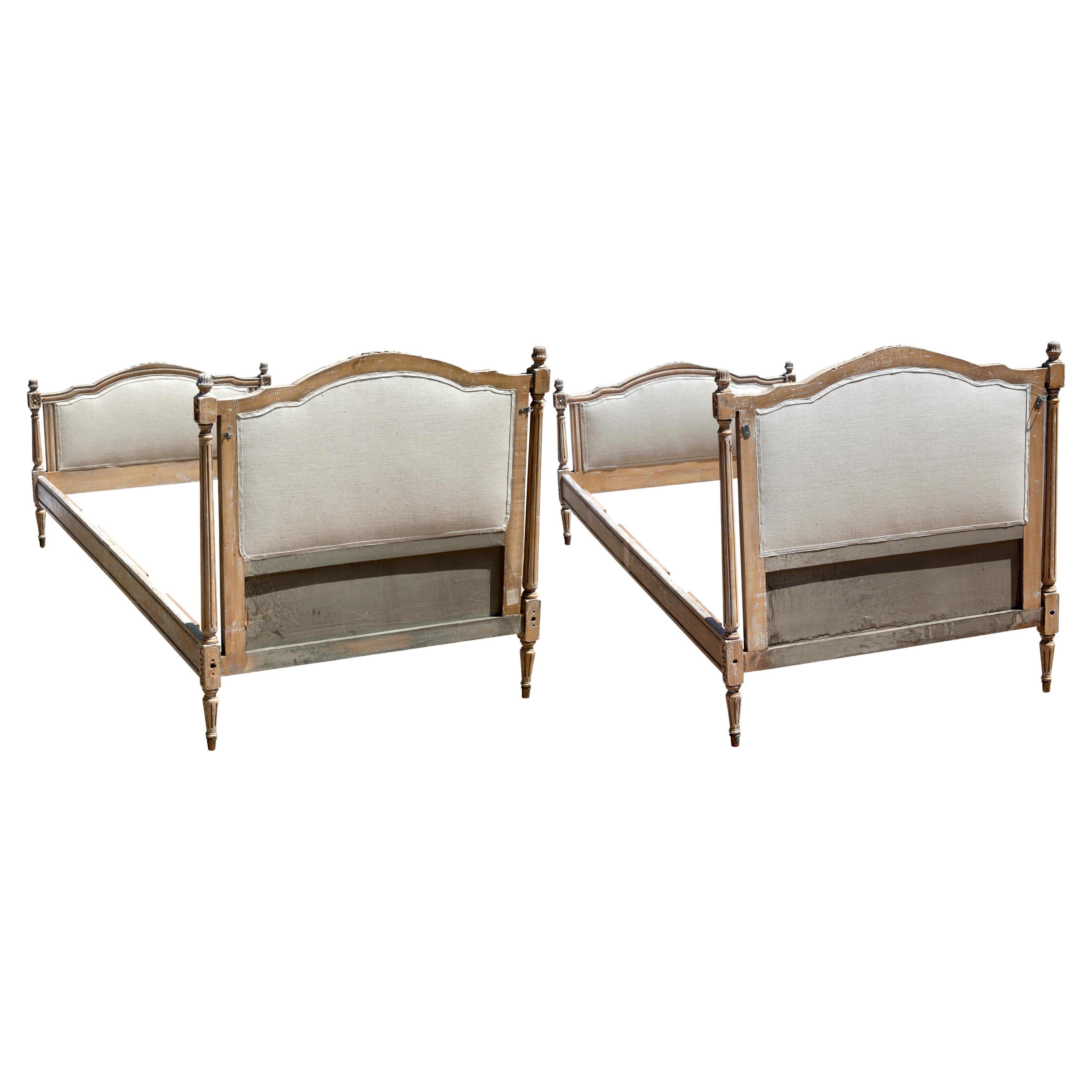 Antique French Louis XVI-style twin beds with original headboards, footboards & side rails. Hand-carved wood frame with original distressed finish with remnants of gilding. newly reupholstered in high quality European linen on both front & back of