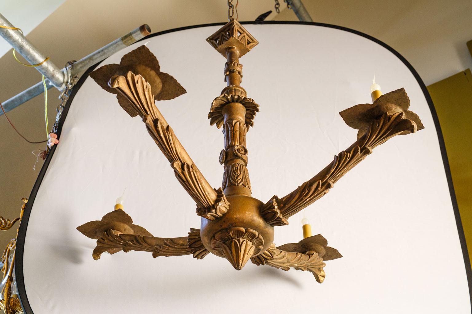 Hand carved giltwood chandelier, circa 1860-1880, Italy. Four arms with candelabra-size lights on later tole bobeche. Includes chain and a canopy. Newly wired for use within the USA. The carving is quite nice and the shape is beautiful.