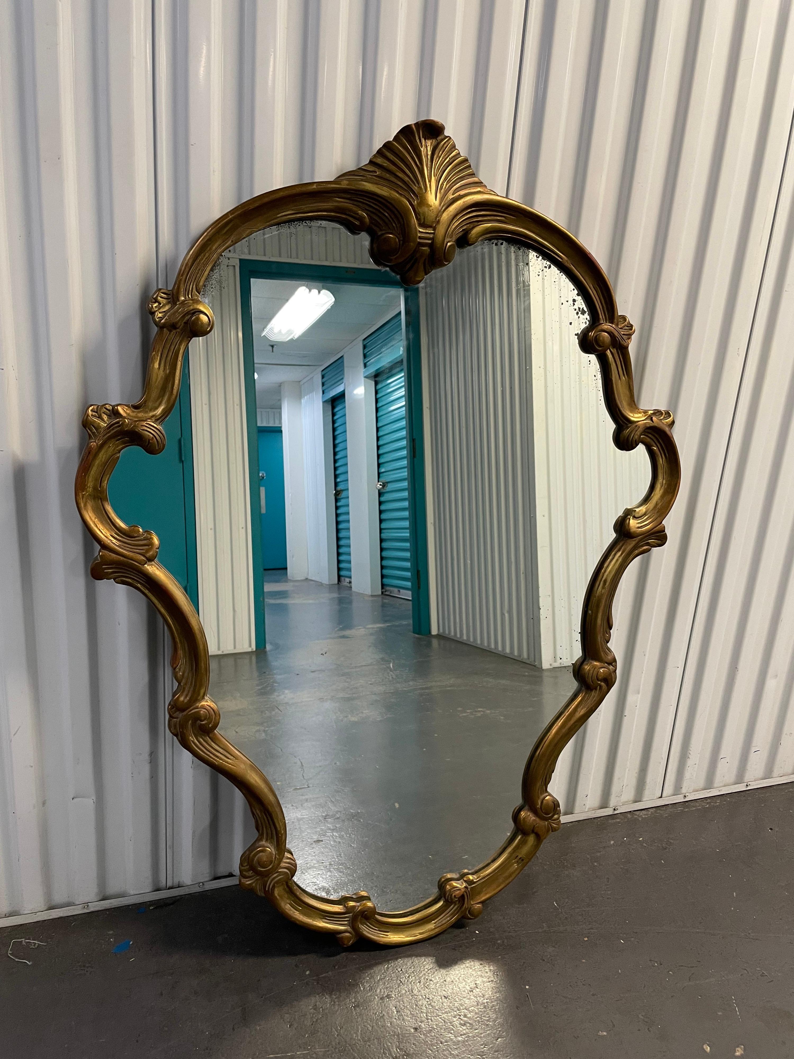 Wonderful flowing carved and gilded Italian mirror with a large carved shell at top center.