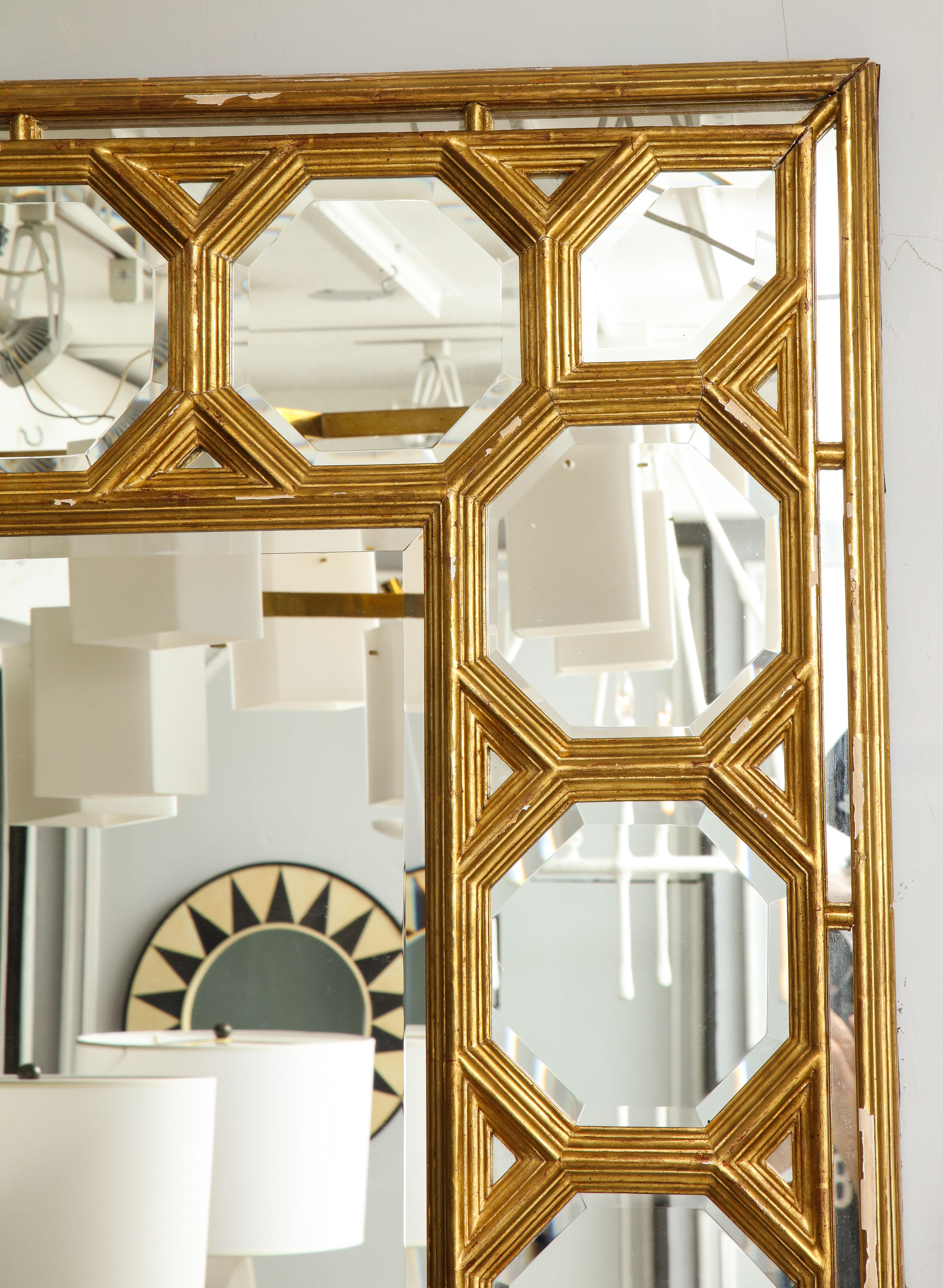 Hand carved giltwood mirror with graphic octagonal design along border.