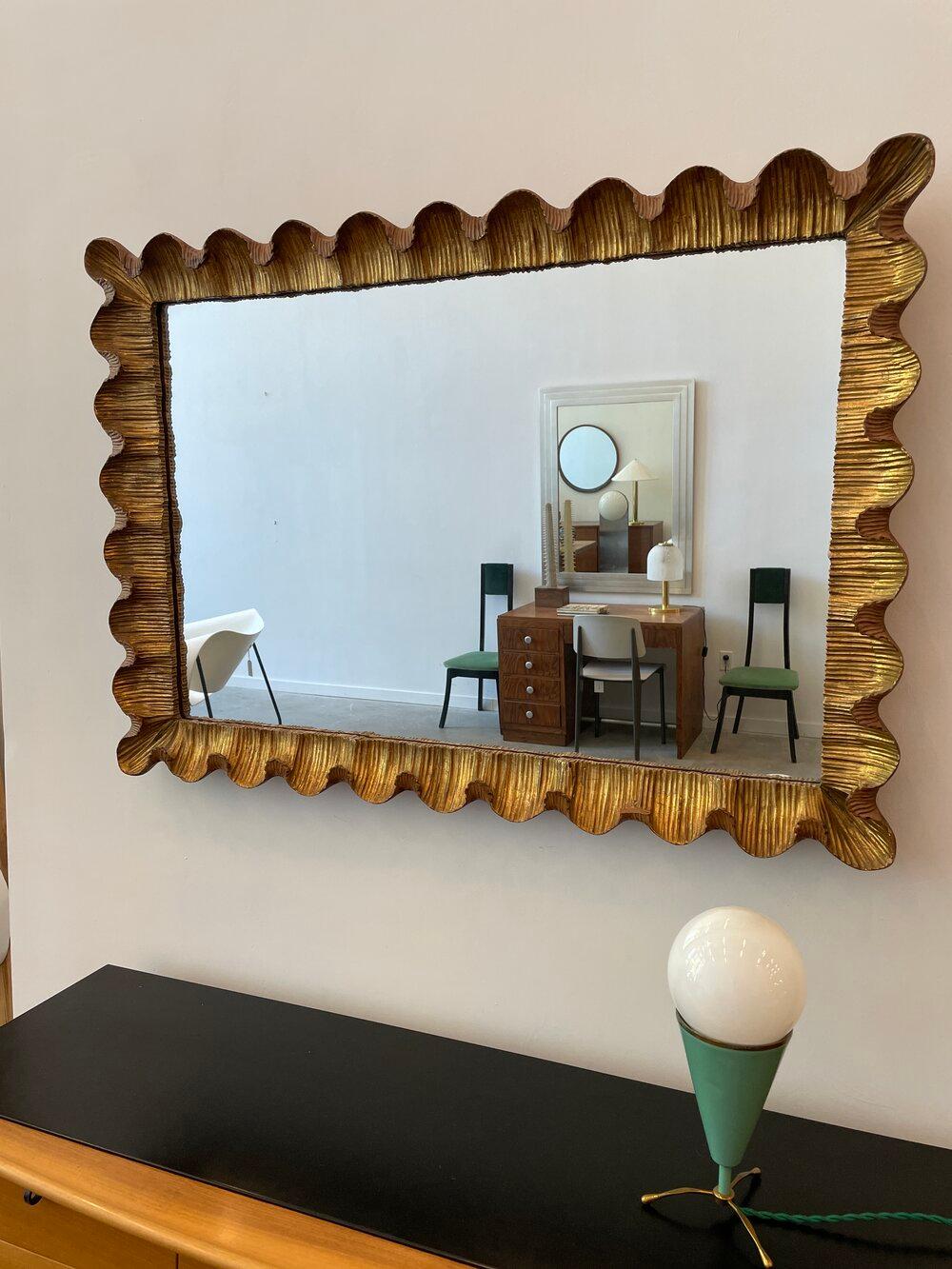Hand carved gilt-wood mirror with scalloped edges.

 