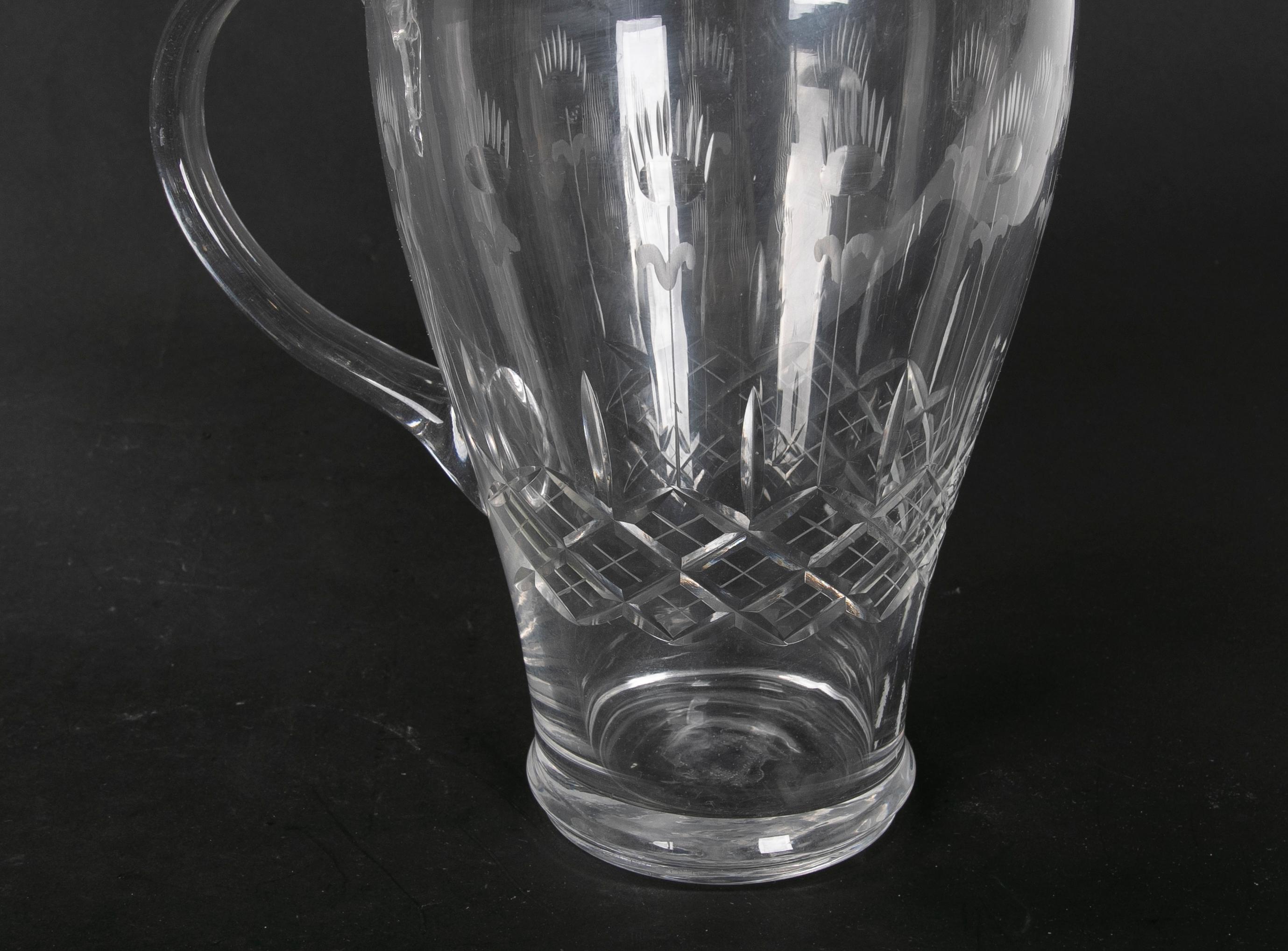 Hand carved glass pitcher with hand carved serving handle.