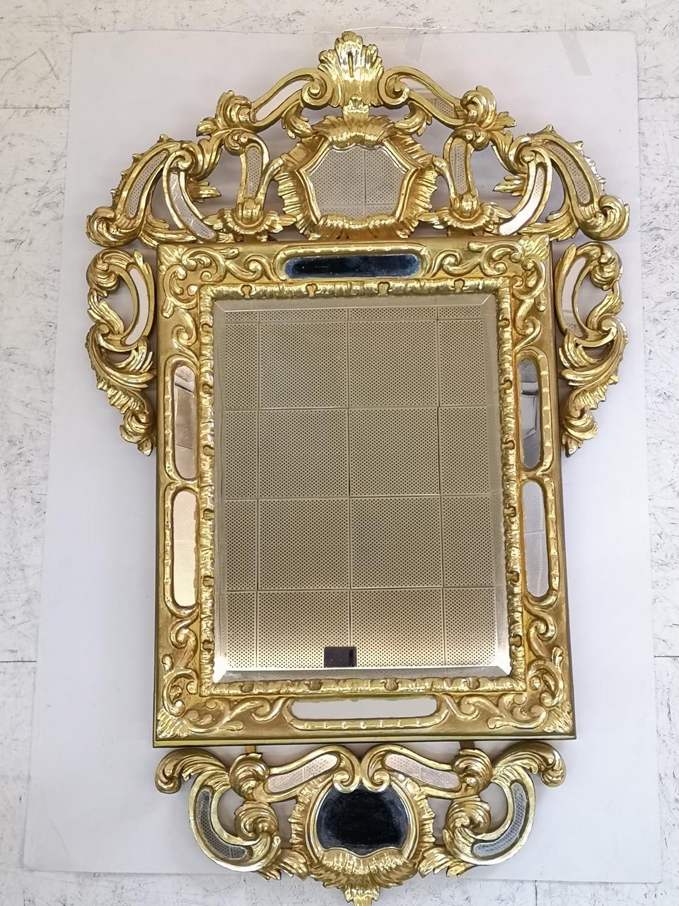 A hand carved and gold-plated wooden mirror, from the 19th century.