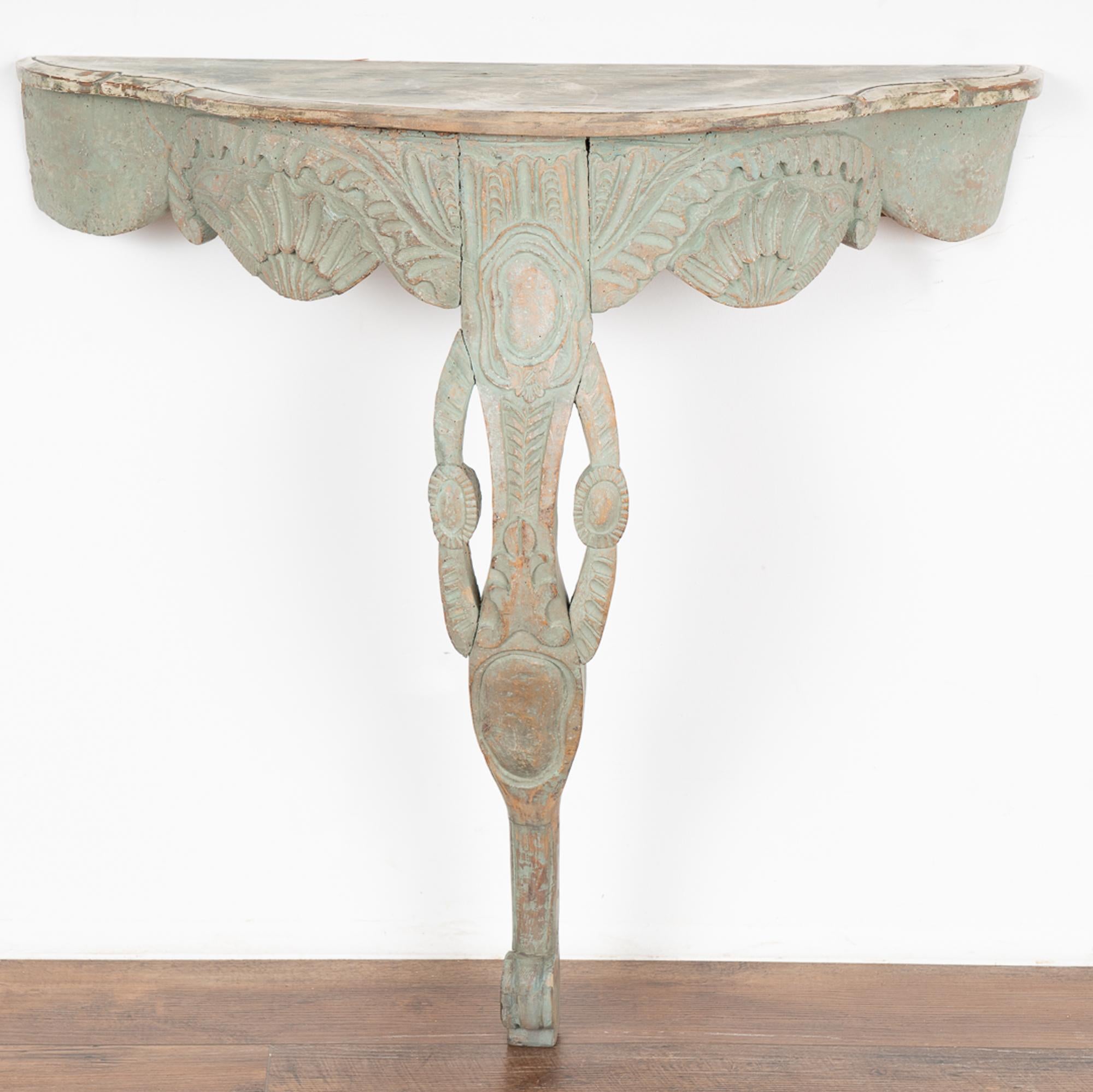 This lovely Norwegian console table has an elaborate hand carved skirt and curvaceous carved single leg.
Note the exquisite aqua color, a soft shade of muted greens (with slight blue undertones) that compliment the romantic appeal of this small