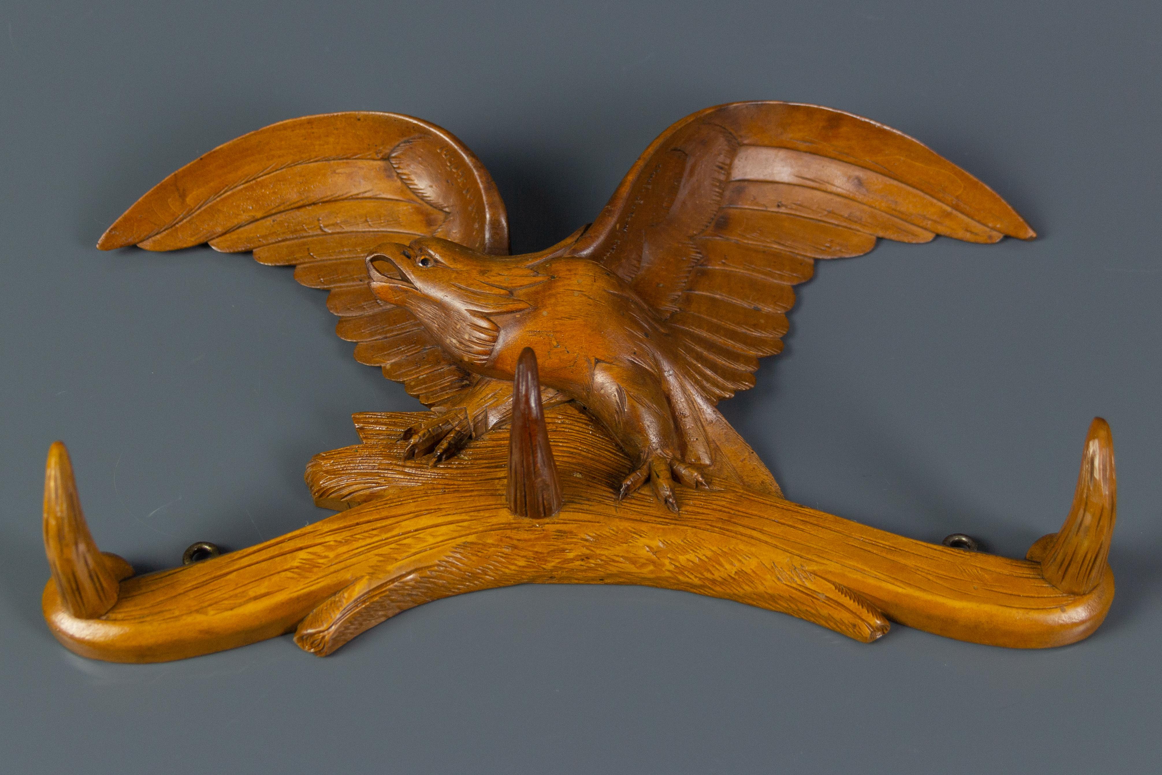 Beautiful hand-carved wood wall mount hat rack with three wooden hooks. An expressive hand-carved figure of an eagle, sitting on a branch. Germany, 1930s.
Dimensions: circa height 19 cm / 7.48 in, length 33 cm / 13 in, depth 6.5 cm / 2.5 in.
 