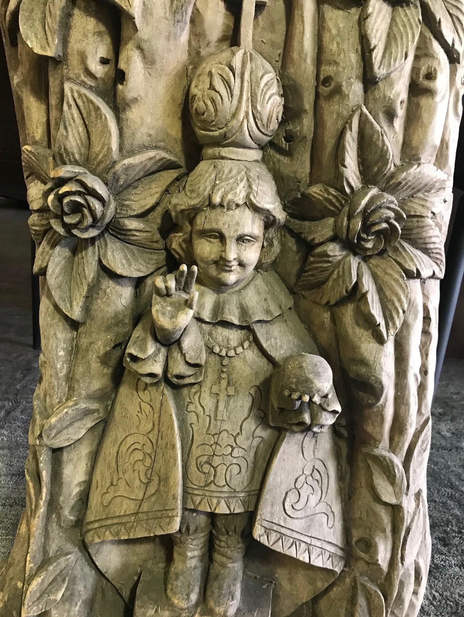 A wonderful, intricately carved, heavy work depicting a religious figure, likely a catholic saint offering his blessing (We have been told that this may be the Holy Infant of Prague (Santo Nino de Praga) or the Infant Jesus of Prague. This piece was