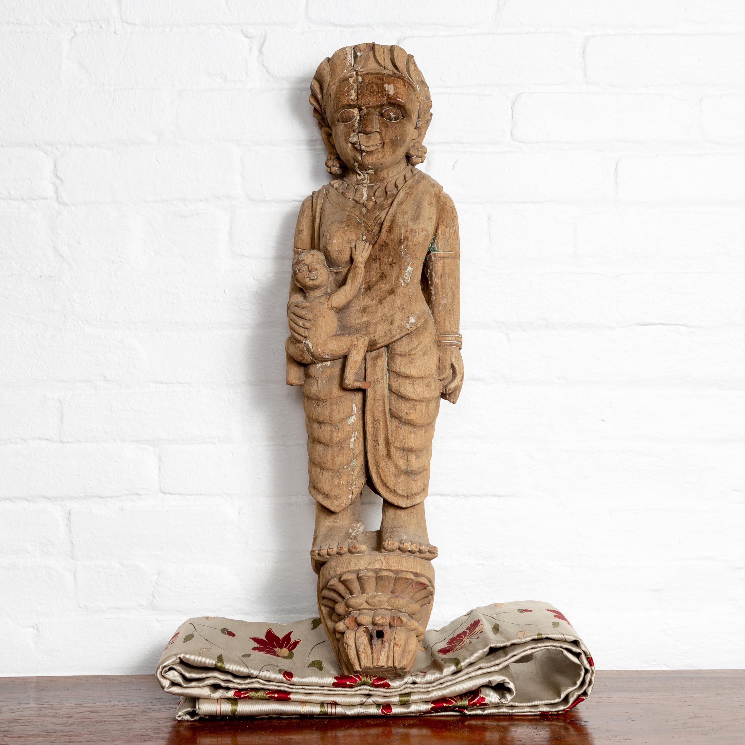 An Indian early 20th century hand carved architectural temple carving from Gujarat, depicting a mother and her child with nicely weathered patina. Crafted in the Western portion of India, in the culturally rich state of Gujarat, this early