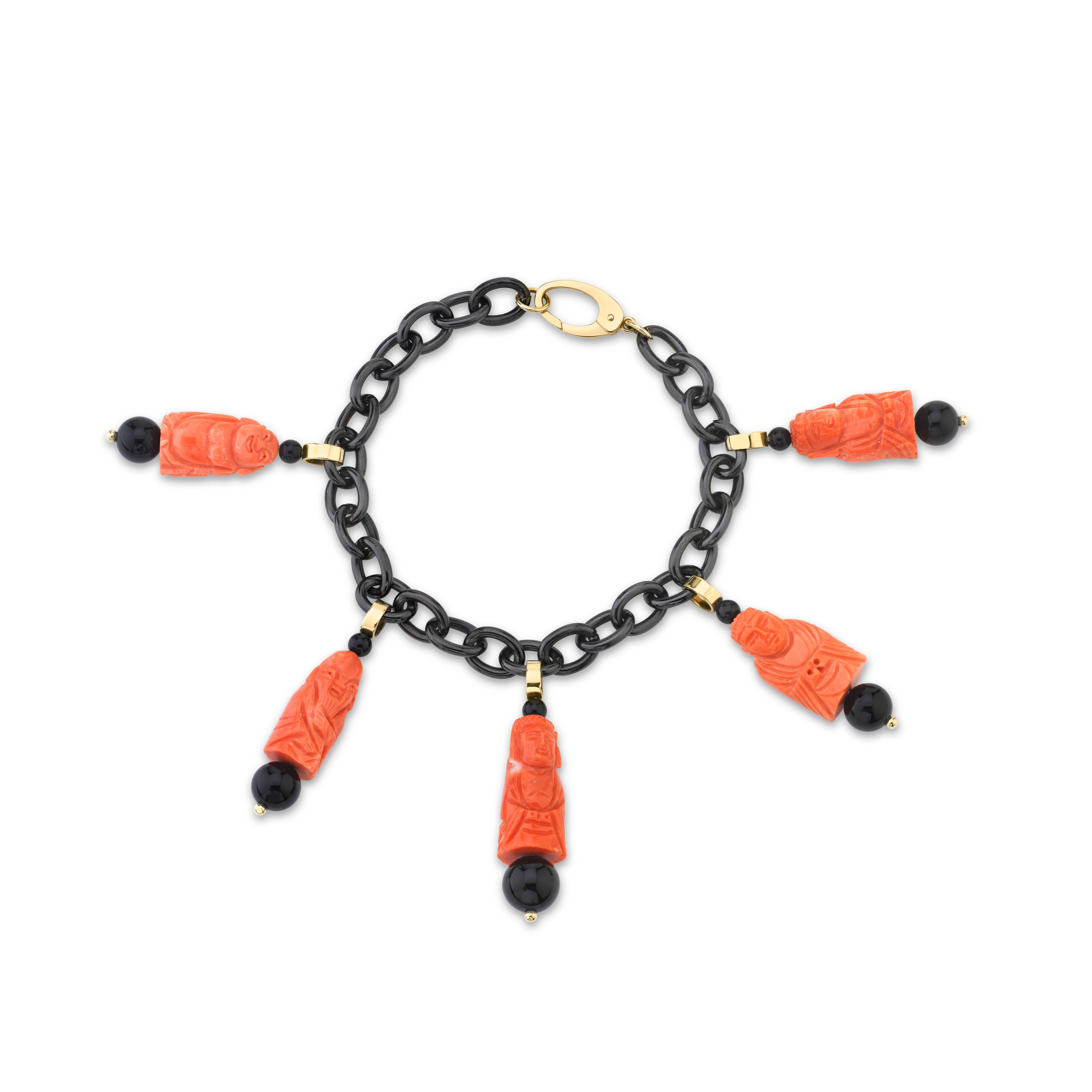 This fun charm bracelet is made of blackened stainless steel links and features 5 Mediterranean coral charms that have been hand carved into happy Buddhas and deities. Set with onyx beads, 18k yellow gold accents and an 18k yellow gold clasp, this