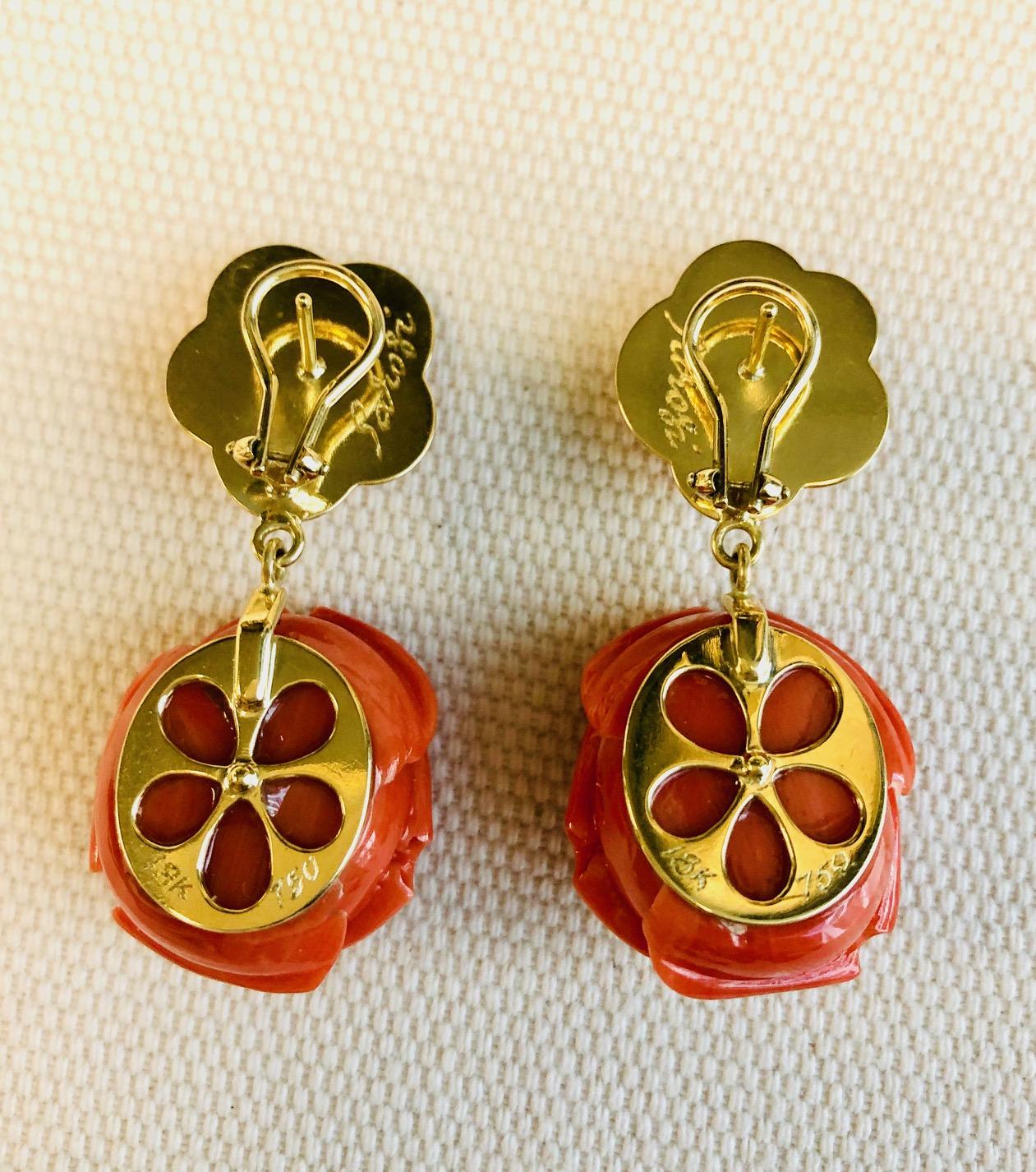 These elegant 18k yellow gold drop earrings feature fine Italian corals that have been hand carved into exquisite roses! Large, naturally colored coral roses dangle below the earlobe, while smaller roses sit on the lobe, secured by French clip