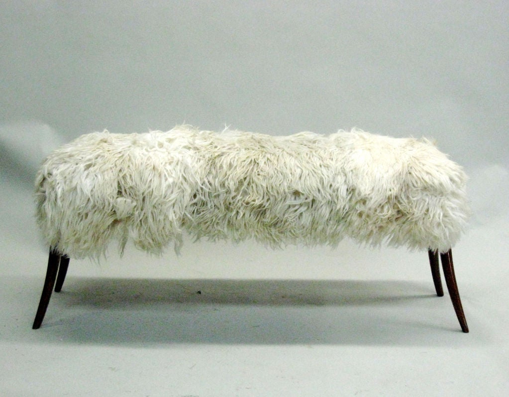 A chic Italian Mid-Century Modern style, hand carved bench or stool with delicately tapering and angled, spalyed legs with the seat covered in long haired goatskin.

Available for order in custom sizes.