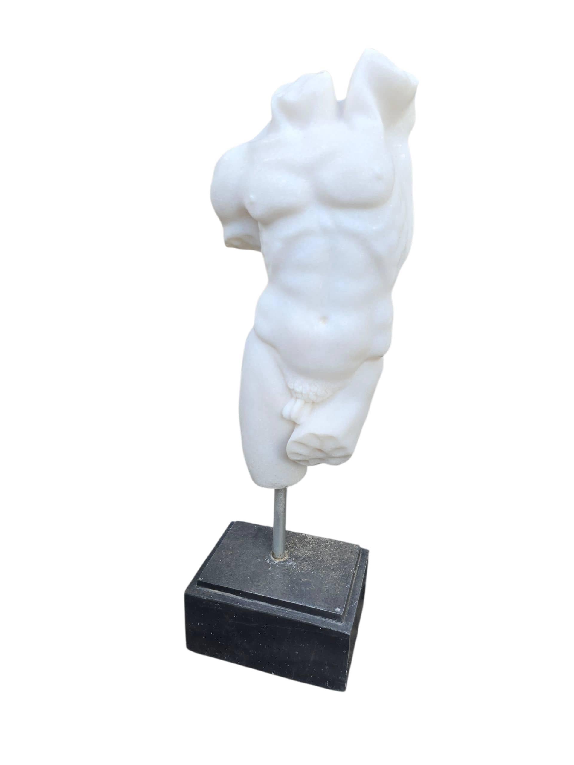 Sculpture décorative en marbre sculptée à la main représentant un torse d'homme grec classique, réalisée en Italie au cours du XXe siècle. Exécutée en marbre blanc fin d'Italie, la pièce met en valeur des formes anatomiques idéalisées et une