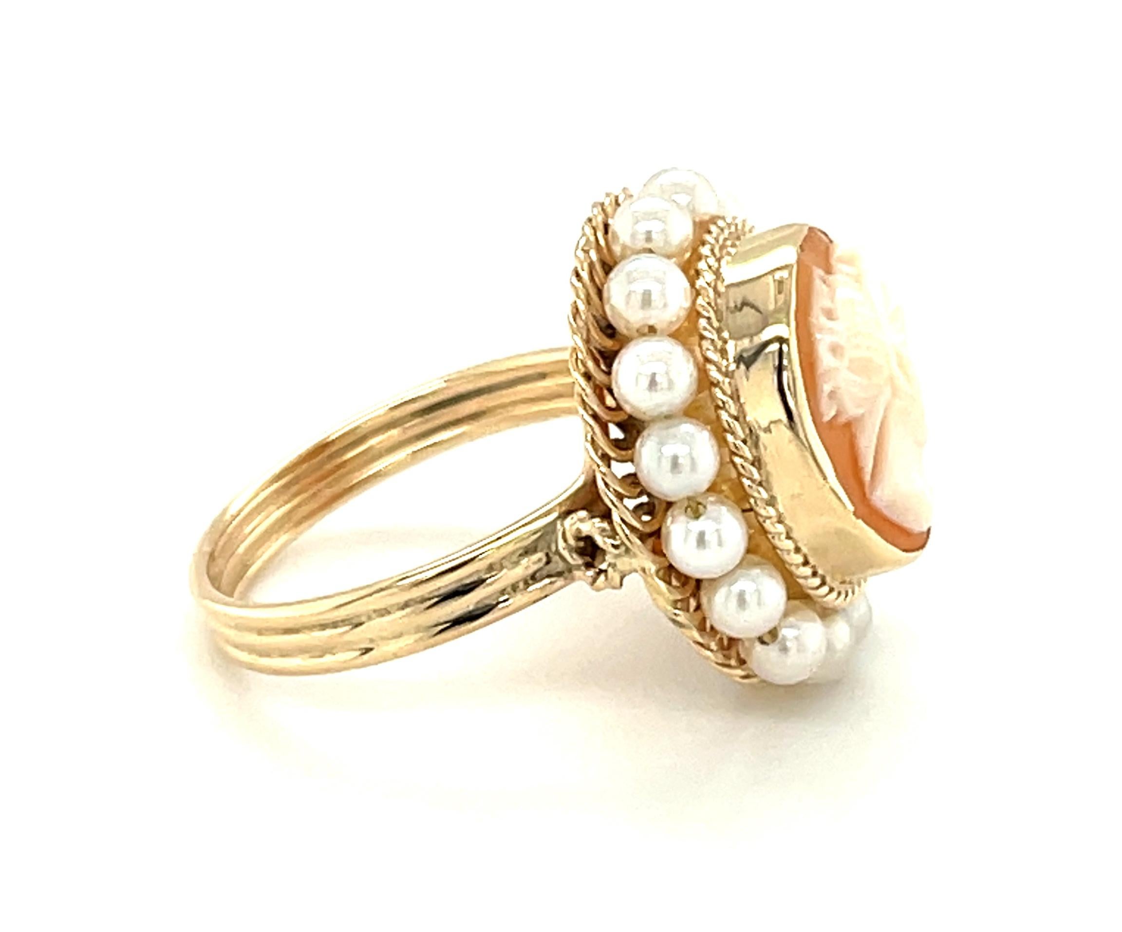 This pretty cocktail ring features a lovely shell cameo that was beautifully hand carved in Italy. The cameo is bezel set and encircled with 3mm seed pearls that have been hand-strung on fine gold wire. The pearls sit atop an intricate frame of fine