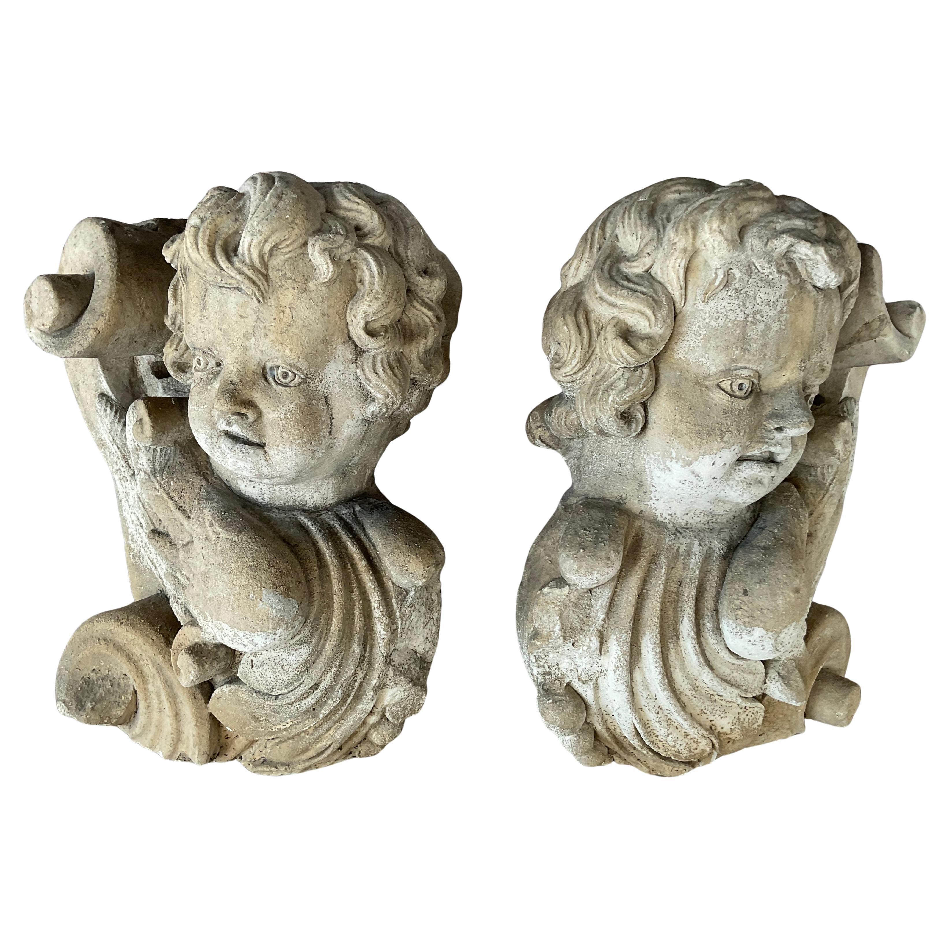 18th Century Italian figural carved stone corbels featuring cherubs, or putti heads, with delicately rendered wings, volutes, and scrolling acanthus motifs. Heavy stone is hand-carved, and the Baroque influence is evident in the dynamic curves,