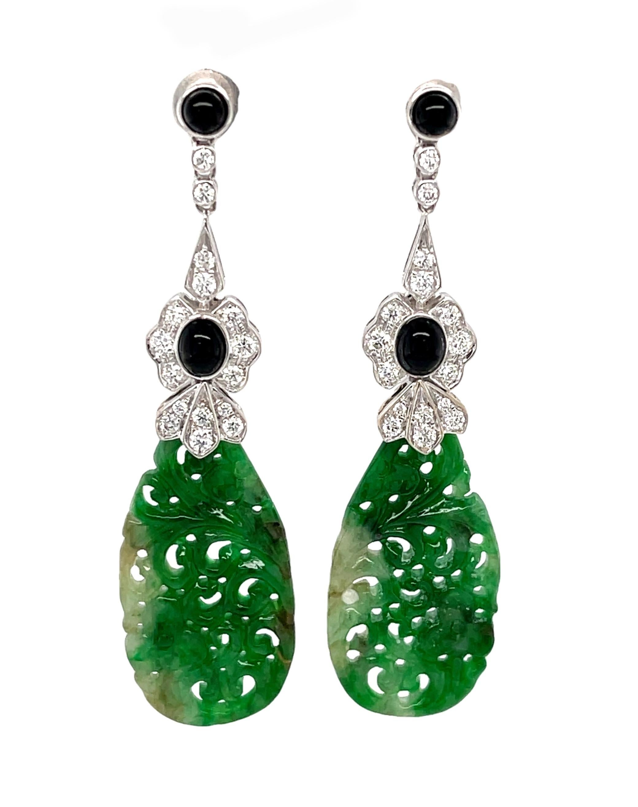 These gorgeous dangle earrings feature beautifully variegated green jade paired with onyx and diamonds in an elegant Edwardian inspired design. Delicate 18k white gold tops intricately set with sparkling diamonds are a perfect complement to the hand