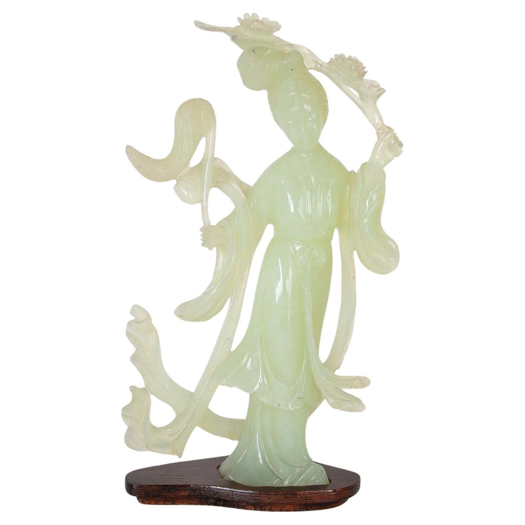 Figurine en jadéite sculptée à la main d'une femme orientale sur une base en bois