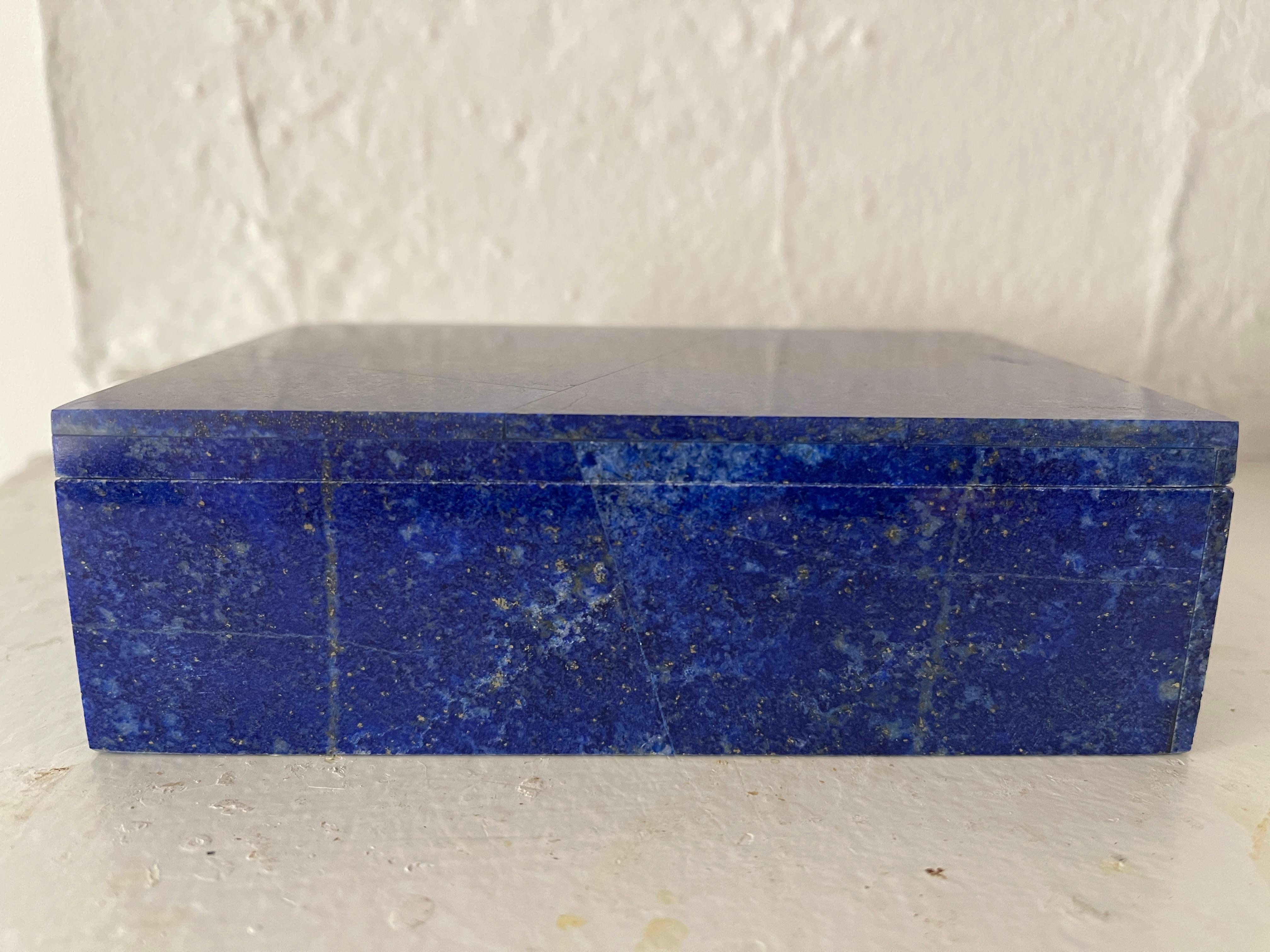 Lapis lazuli hand carved mosaic lidded box, with white marble interior. 
Natural lapis stone has beautiful golden pyrite inclusions, like a sprinkling of fairy dust. The lapis mosaic covers entire exterior of the box.
Marble interior bottom has