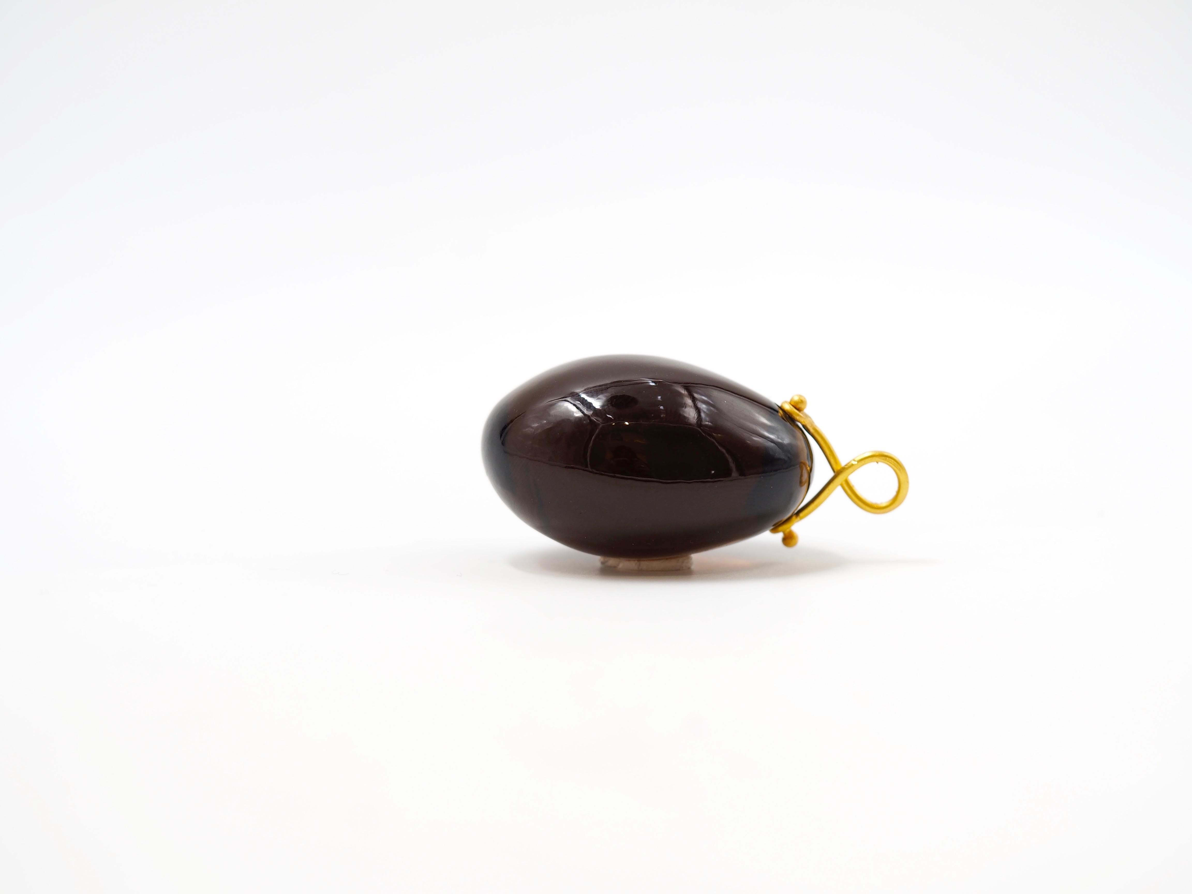 Hand-carved and handmade pendant, this stone is simply drilled to allow a 22 karat gold wire that is twisted to make a ring. 
This large pendant has a smoky quartz of approx 140 carats. 
3 stone sizes exist as you can see on the photo. 
The stone