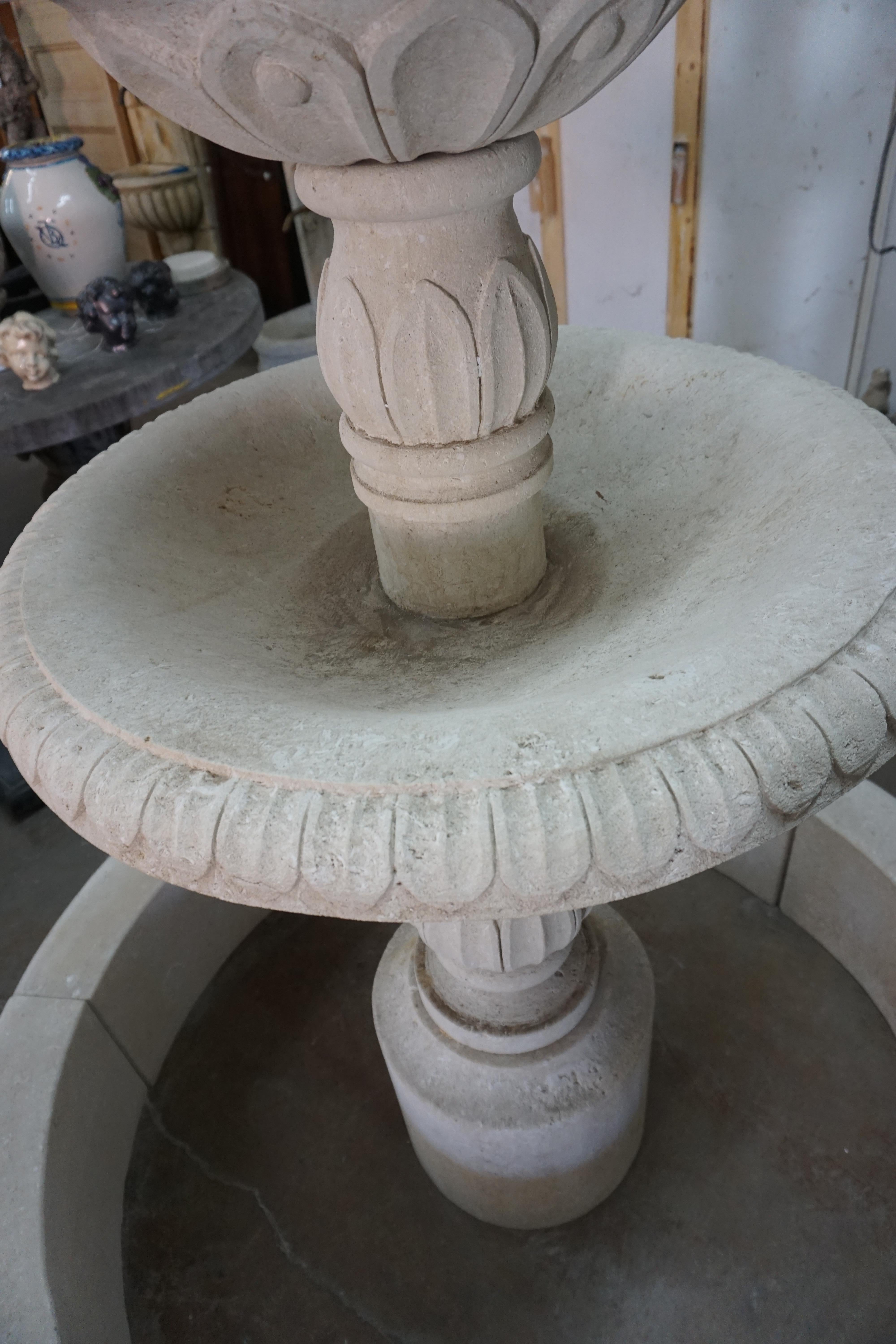 Améliorez votre espace extérieur avec cette fontaine centrale en pierre calcaire française. Sculptée à la main en France et importée d'Europe, cette fontaine de style central présente un bassin circulaire avec un pilier central et deux niveaux pour
