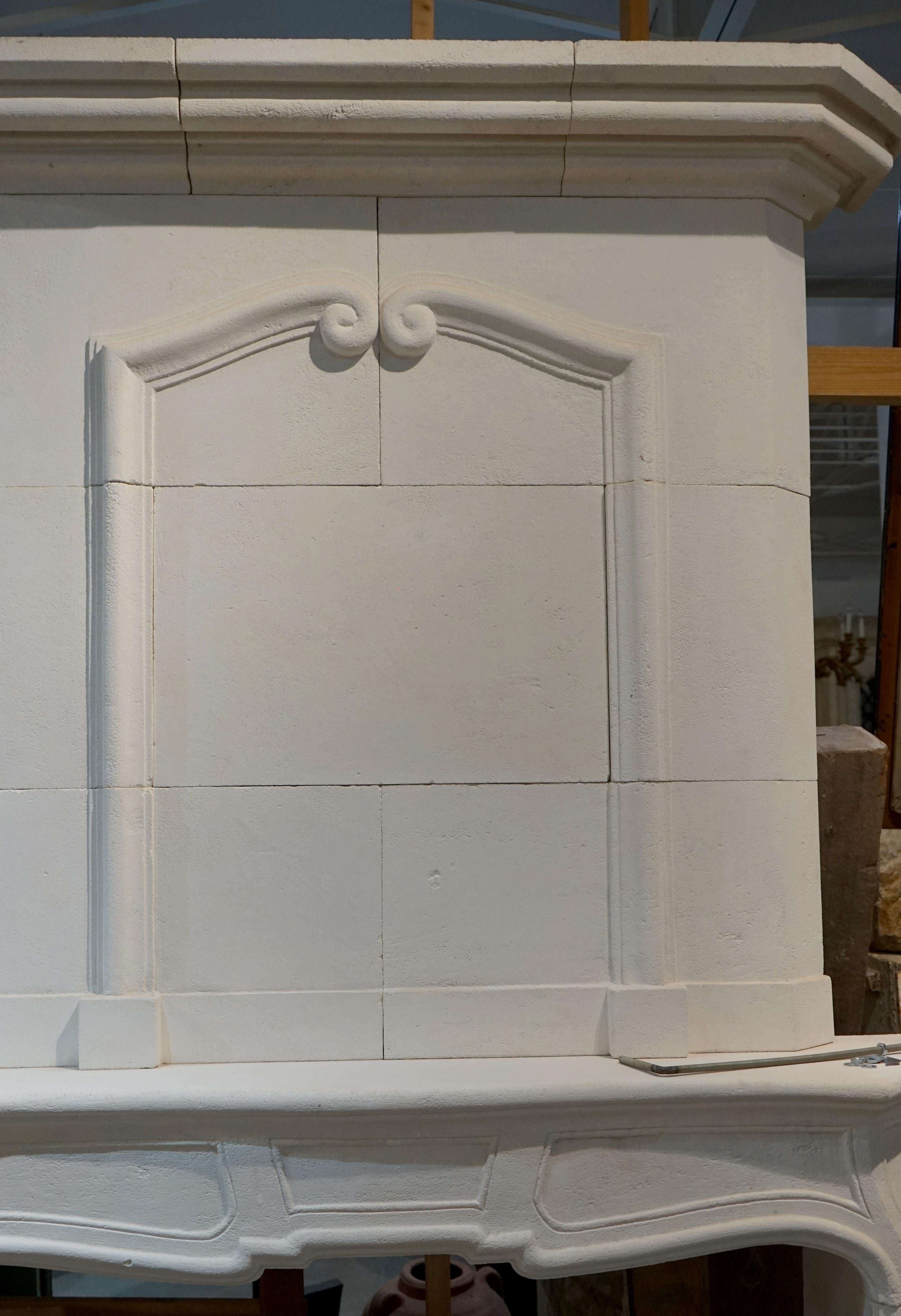 Hand carved from white limestone, this mantel has a scroll-like design at the top of the panel and architectural line along the legs and lentil.

Measurements: 66