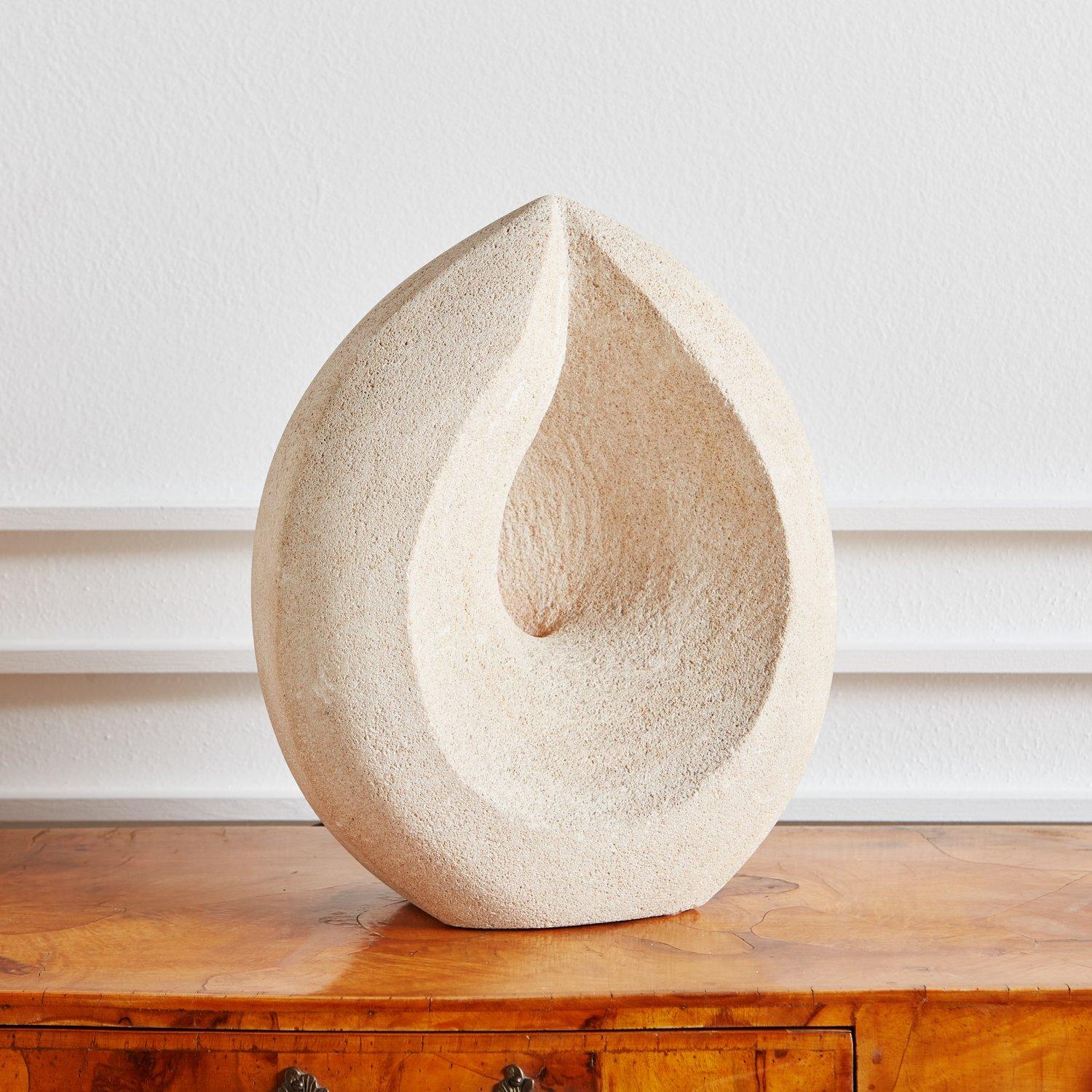 A French hand carved porous limestone lamp in the style of Albert Tormos. This sculptural lamp has a unique tear drop shape with a slight center opening to allow warm light to emanate. France, 1970s. 

