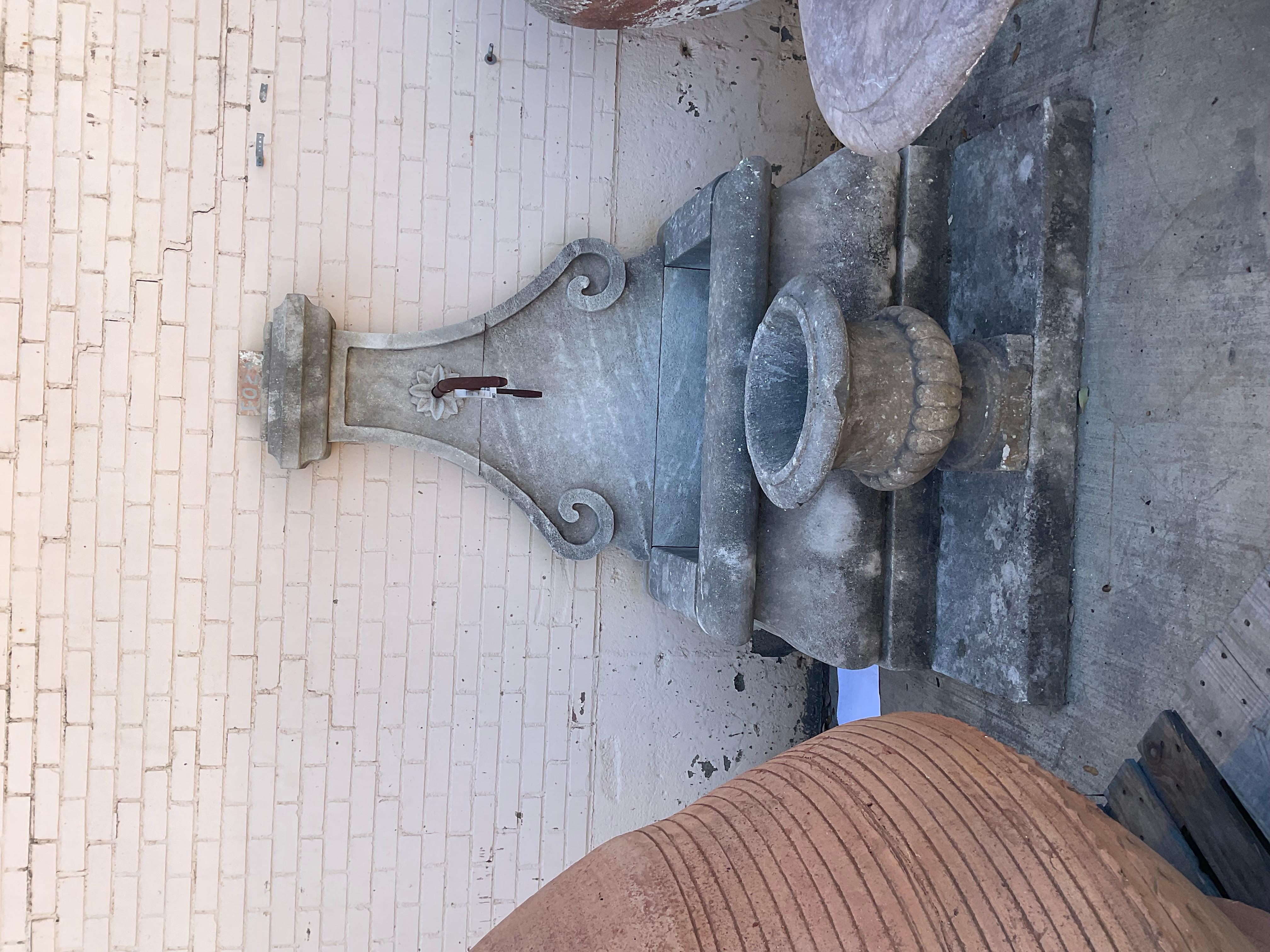 Here we offer a hand carved limestone wall fountain with a bronze down spout. This fountain is modeled after an antique design for a small village fountain our partners in France reclaimed near Marseille, France. A fountain like this will not only