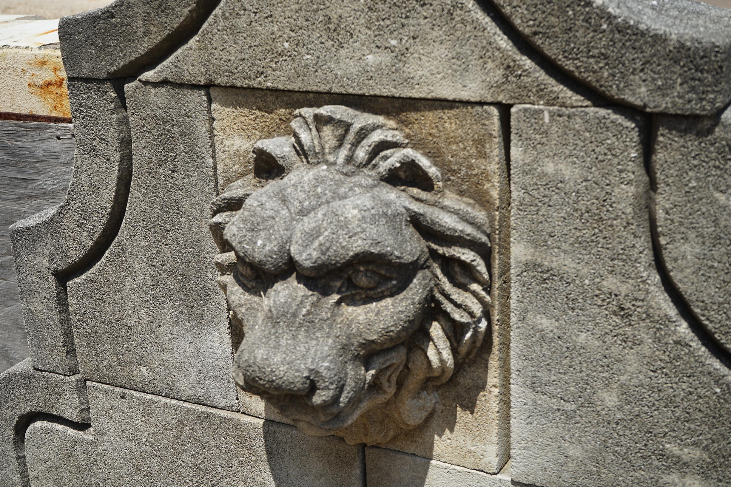 This hand carved limestone wall fountain displays a lion head with its mouth drilled for a water exit. This simple fountain has a Classic shape to the back plate and nice movement on the basin wall. Allow this limestone fountain, carved in the South