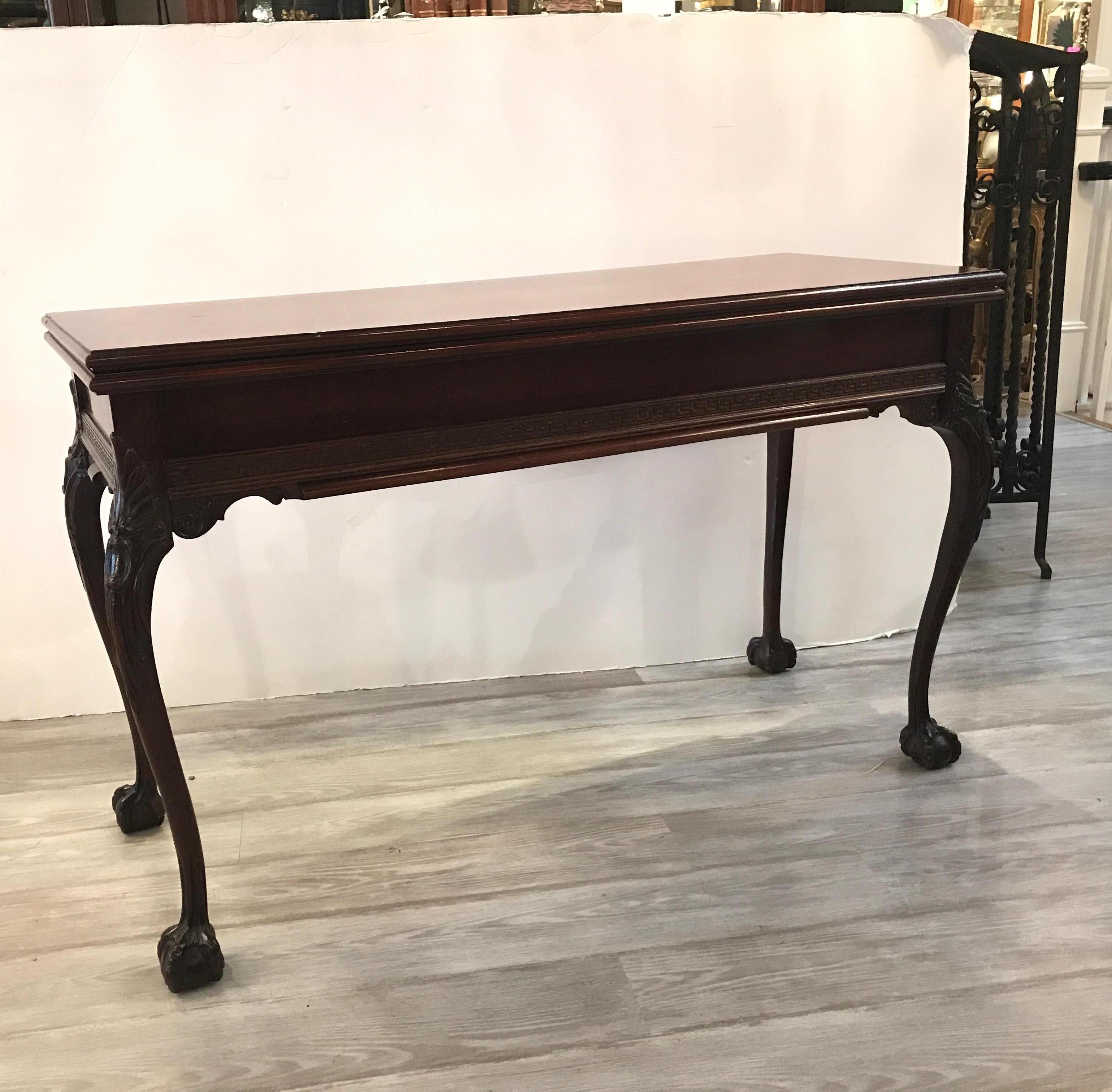 Wonderful Chippendale style mahogany console table that opes to a dining table. The top flips open to double the surface. The two side legs pull out to open the table even large with three 11.5 inch leaves. The top flips and you attach the leaves on