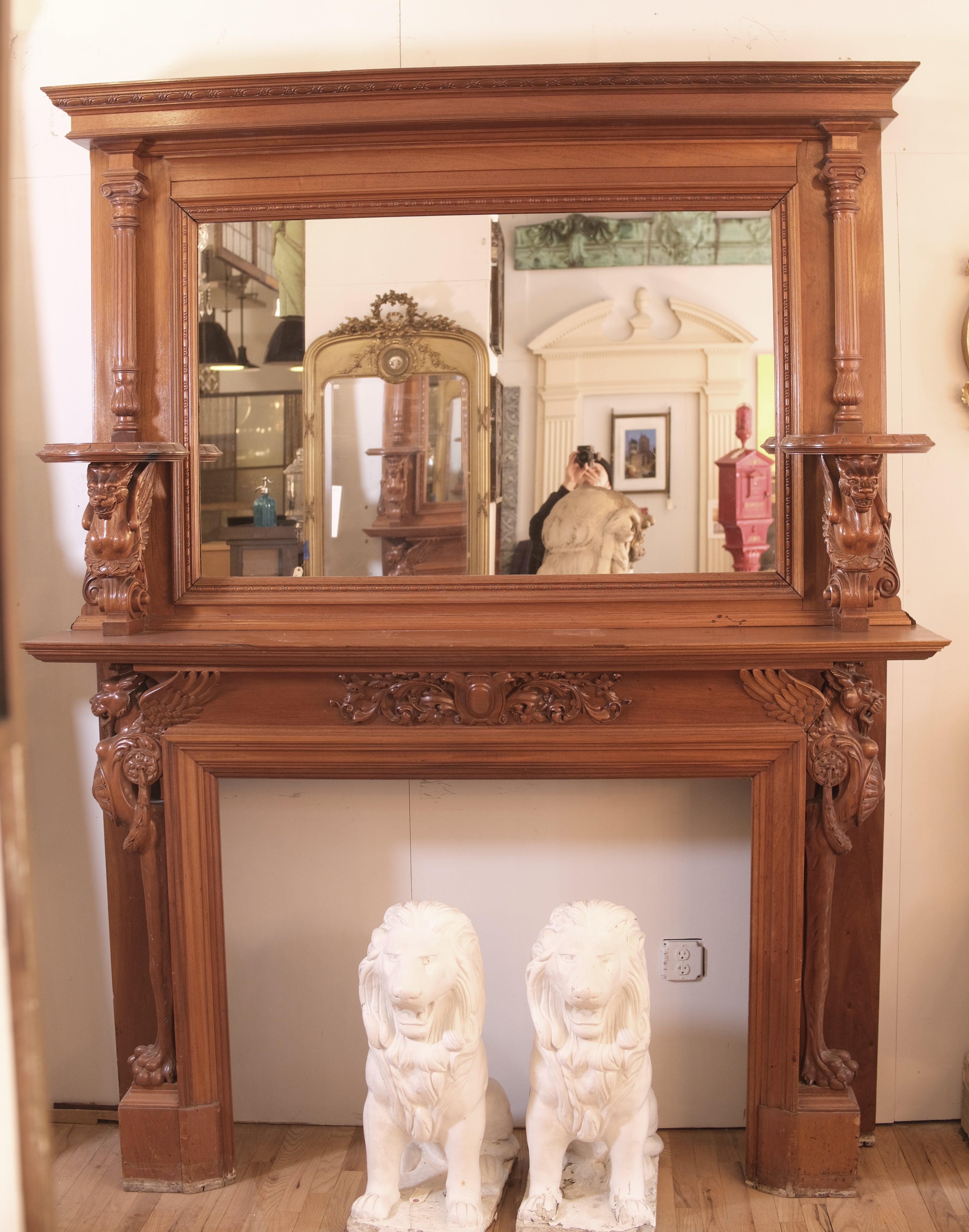 Late 1800s American hand carved mahogany mantel. Features over the top details including four separate griffins flanking the two sides with columns. Also features flower and floral details with leaves and stylized dragons feet on the bottom resting