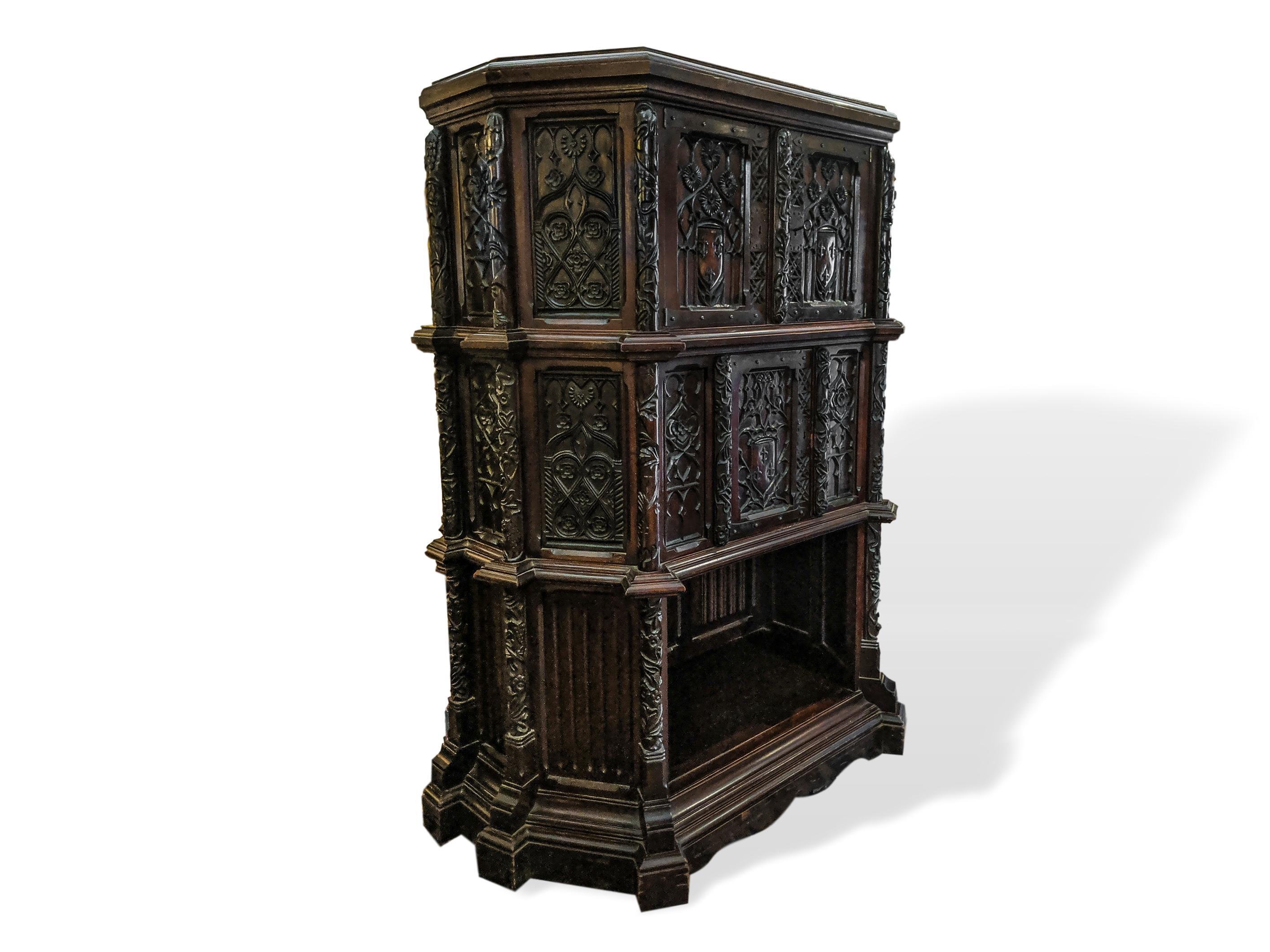 Hand carved mahogany Gothic revival cabinet court cupboard, Belgium, circa 1880, with two doors over a single door with large solid brass strap hinges. 

Dimensions: Height 63