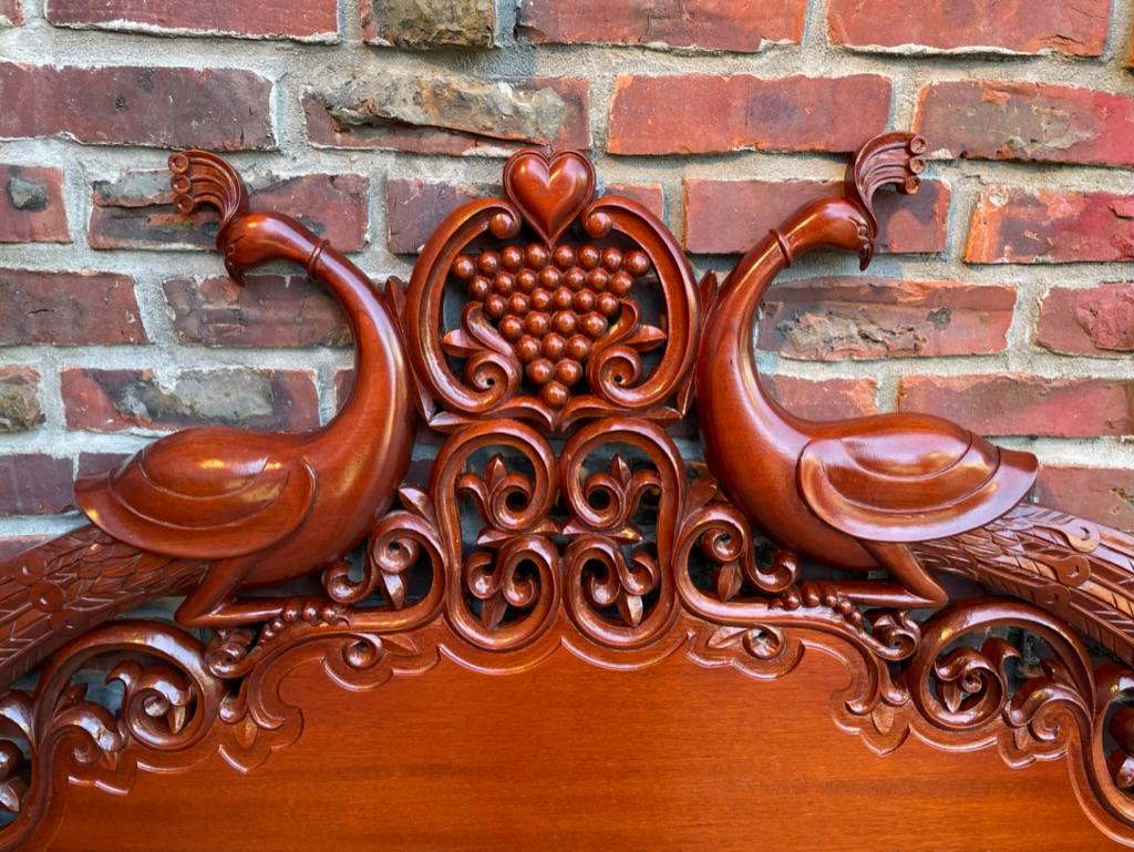 One of a kind custom made hand carved Mahogany headboard. Decorated with a pair of peacocks on either side of a heart. Exquisitely carved of the best quality Honduran Mahogany by a master craftsman for a custom order. Full size bed, outside