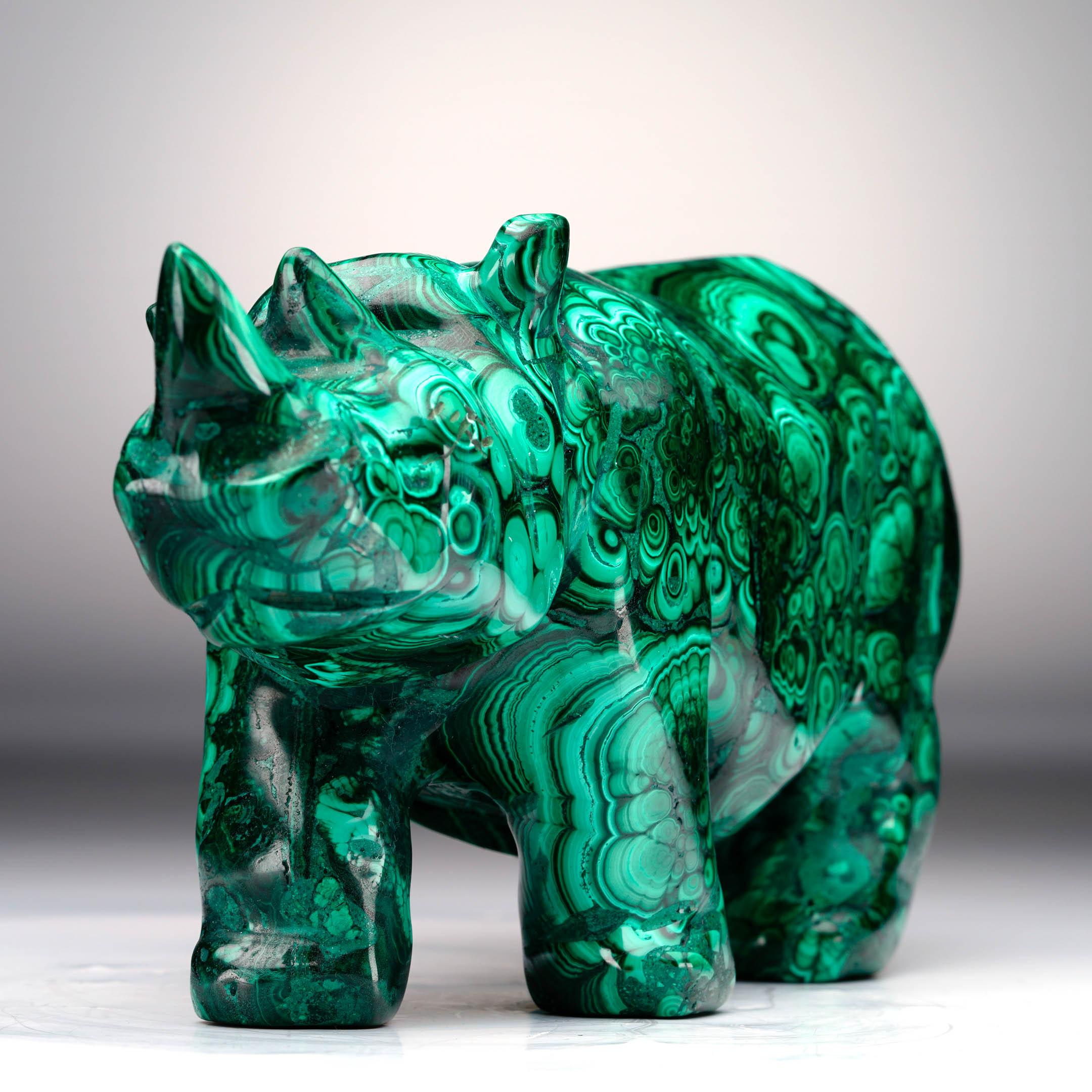 Ce rhinocéros en malachite sculpté à la main est un élément décoratif audacieux qui célèbre à la fois l'art et la nature. Sculptée dans une seule pièce de malachite authentique, la sculpture révèle des teintes vertes vibrantes avec des bandes