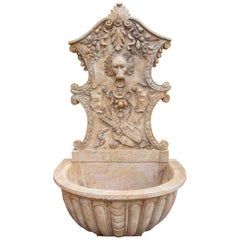 Fuente de mármol tallada a mano con mascarón de proa de león e instrumentos musicales.
