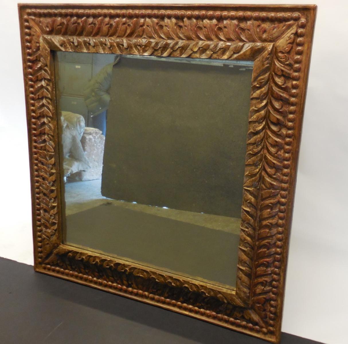 Hand carved and hand finished mirror with layers of gesso and paint. Aged mirror glass.