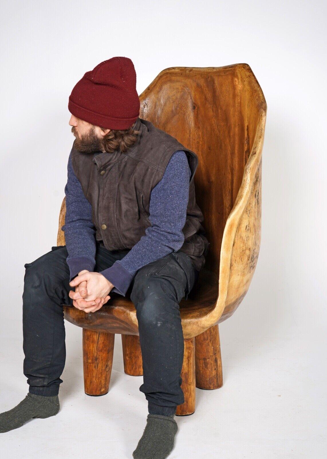 A beautifully tactile Naga barrel high back chair. A primitive hand carved chair made form Naga Wood. This rustic piece is low and cosy and surprisingly comfortable to relax in. A standout occasional chair that will look fantastic in any room in