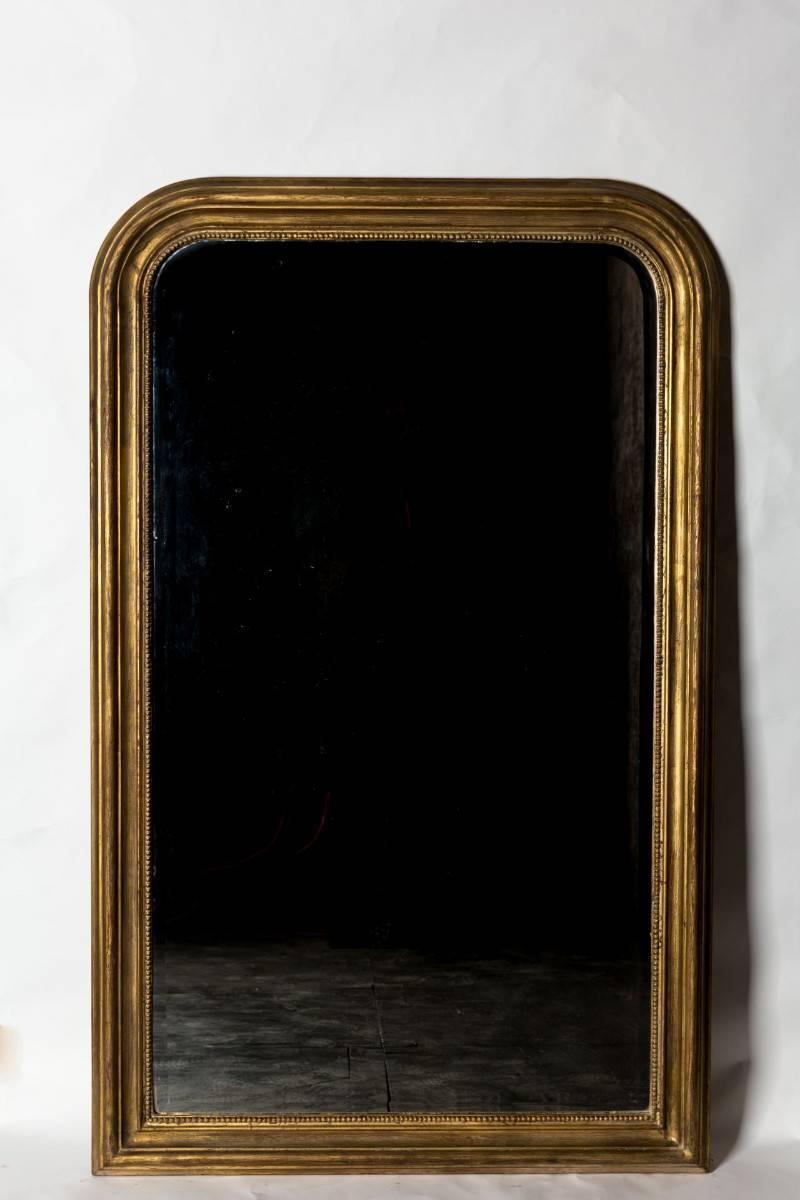 Hand carved with beaded detail and exquisite aged gilt painting technique, this piece was created in Biarritz, France and has a lovely beveled edge mirror installed. Beautiful when placed on the wall, leaned on top of a piece of furniture or leaned