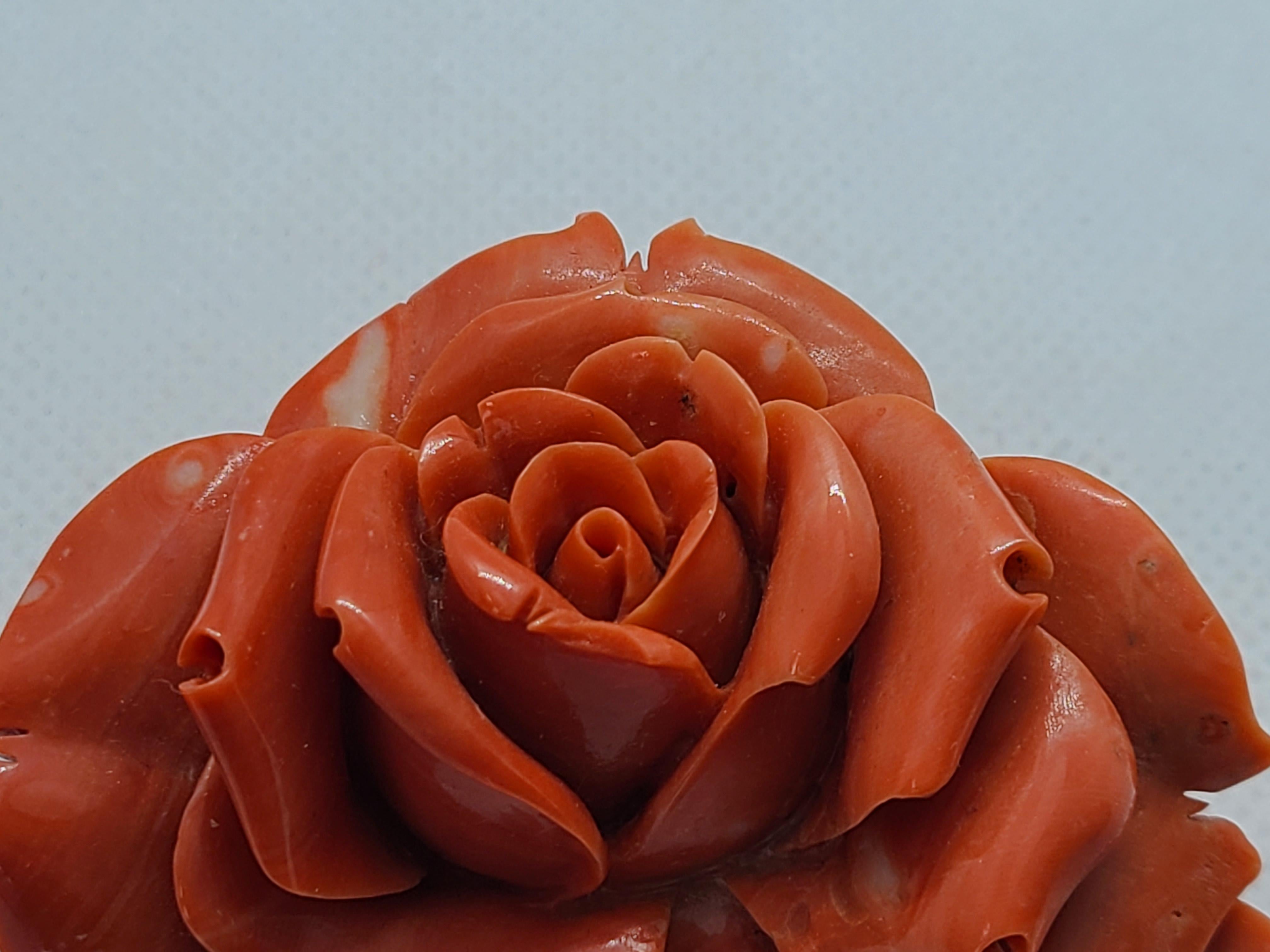 Dieses exquisite Ornament besteht aus einer natürlichen orange-roten Koralle, die in aufwändiger Handarbeit in die Form einer blühenden Rose geschnitzt wurde - ein dauerhaftes Symbol für Schönheit und Liebe. Es misst etwa 7,2 × 5,5 × 2,2 cm und