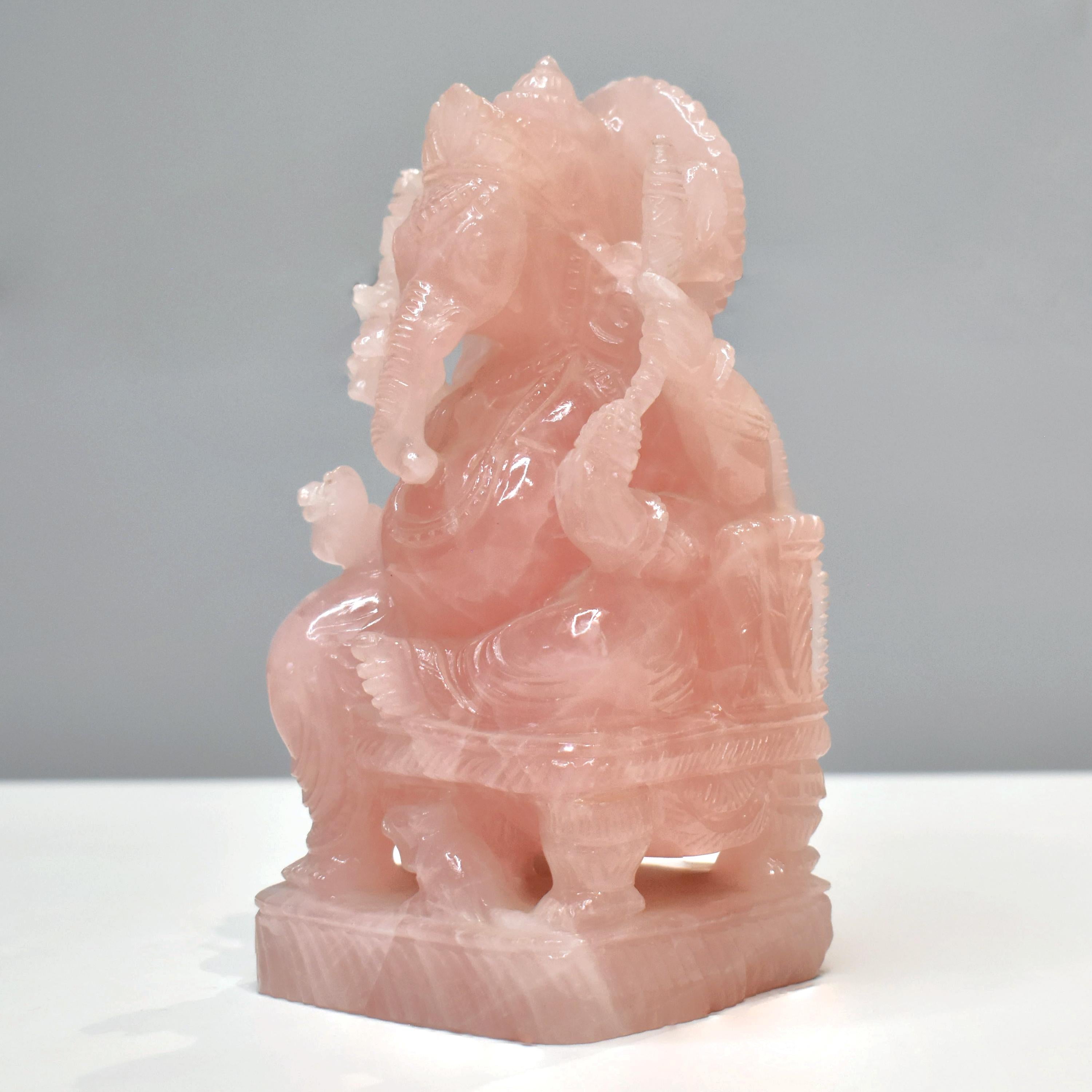 Invite divine blessings, harmony, and loving energy into your space with this stunning Lord Ganesha idol, hand-carved from natural rose quartz. Measuring 16.3 cm in height and 8.5 cm in width, this intricately detailed sculpture captures the serene