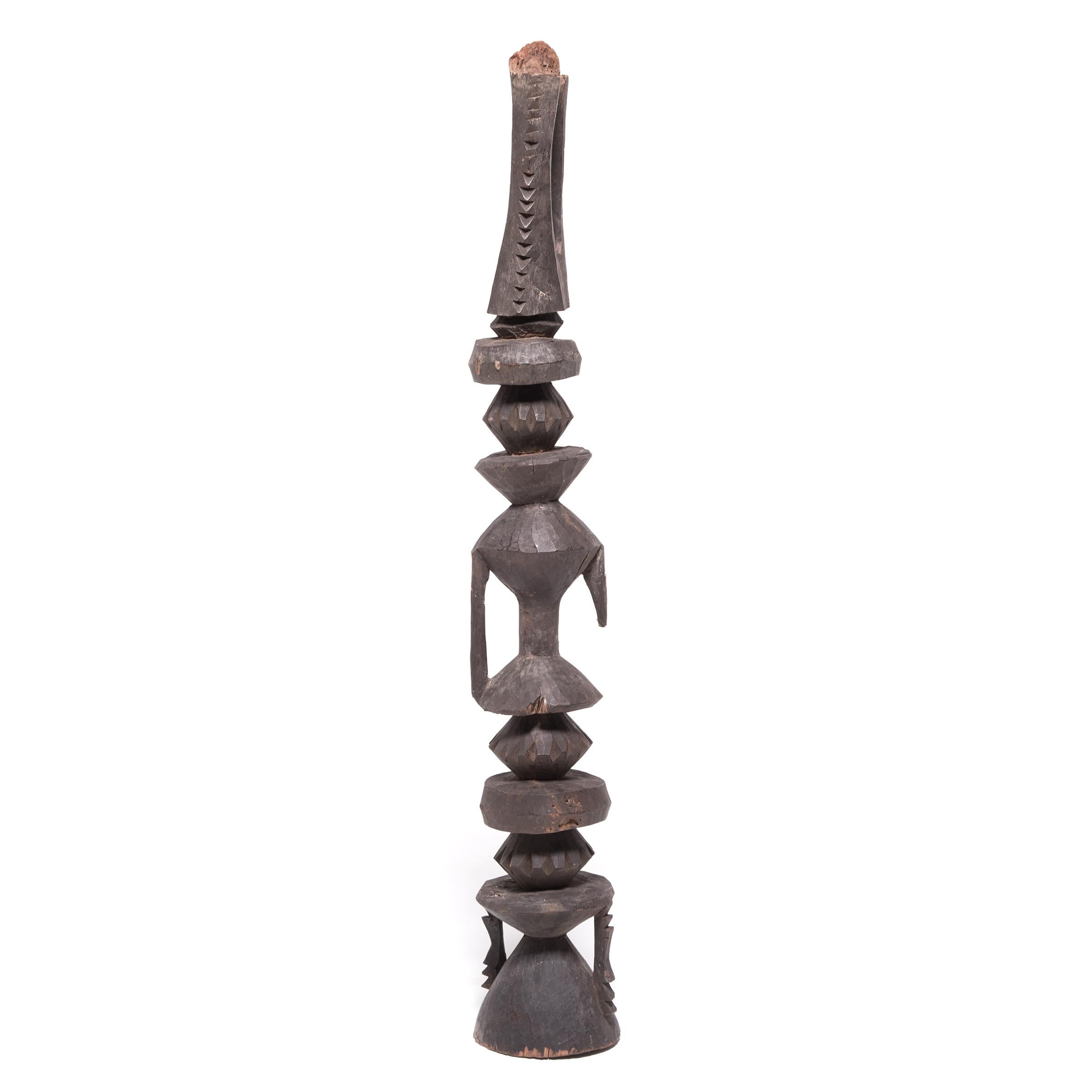 Crafted by an artisan of the Nupe peoples of Nigeria and Cameroon, this wooden post was originally part of the central beam supporting the roof of a home. Support posts such as this are typically carved with simple geometric forms, rather than