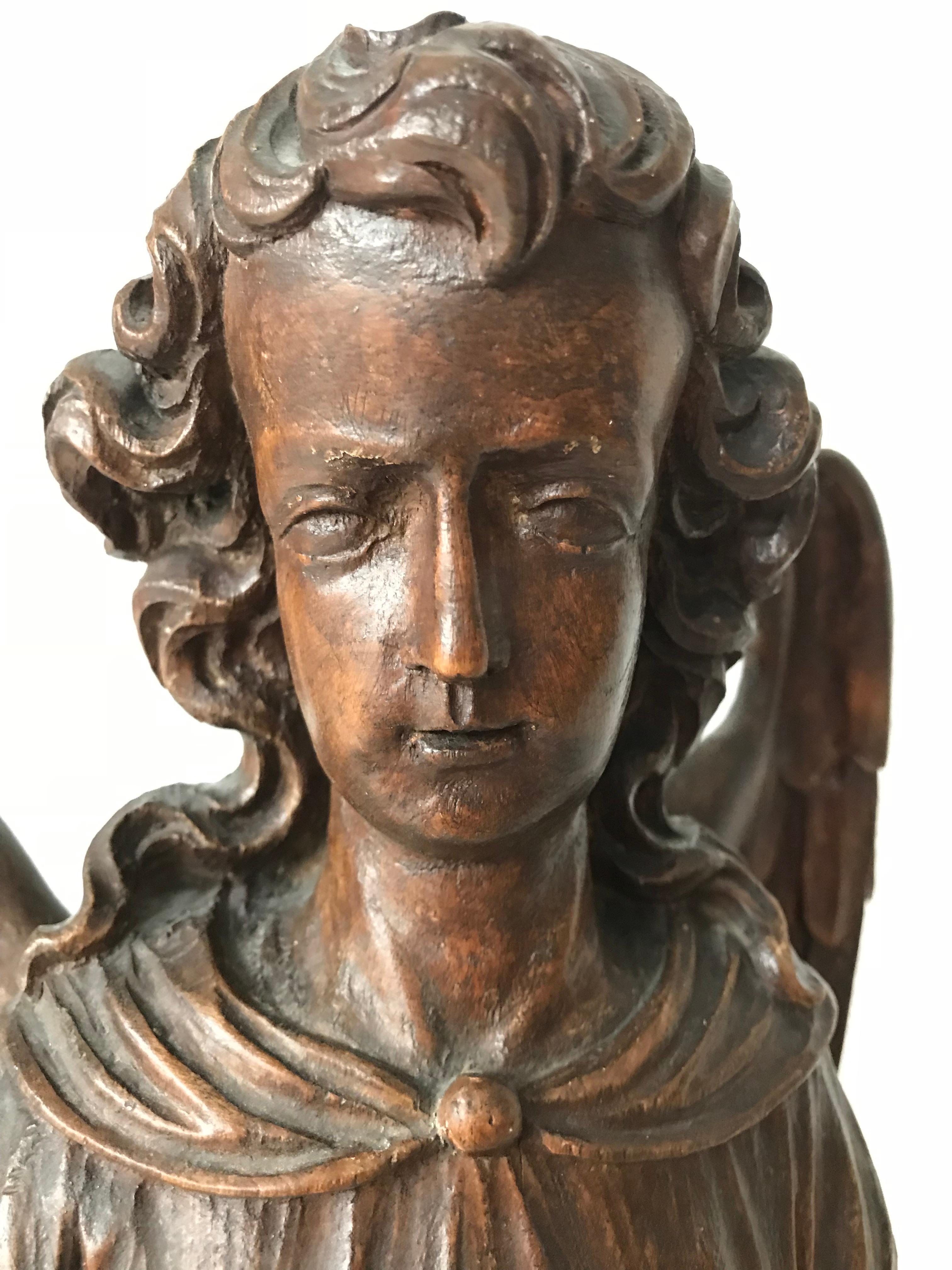 Antique solid wooden, standing angel.

This rare angelic sculpture is entirely hand-carved out of wood. His beautifully flowing, long hair and arched wings, make us believe that this could be a rare sculpture of Earth Angel Michael. One without his