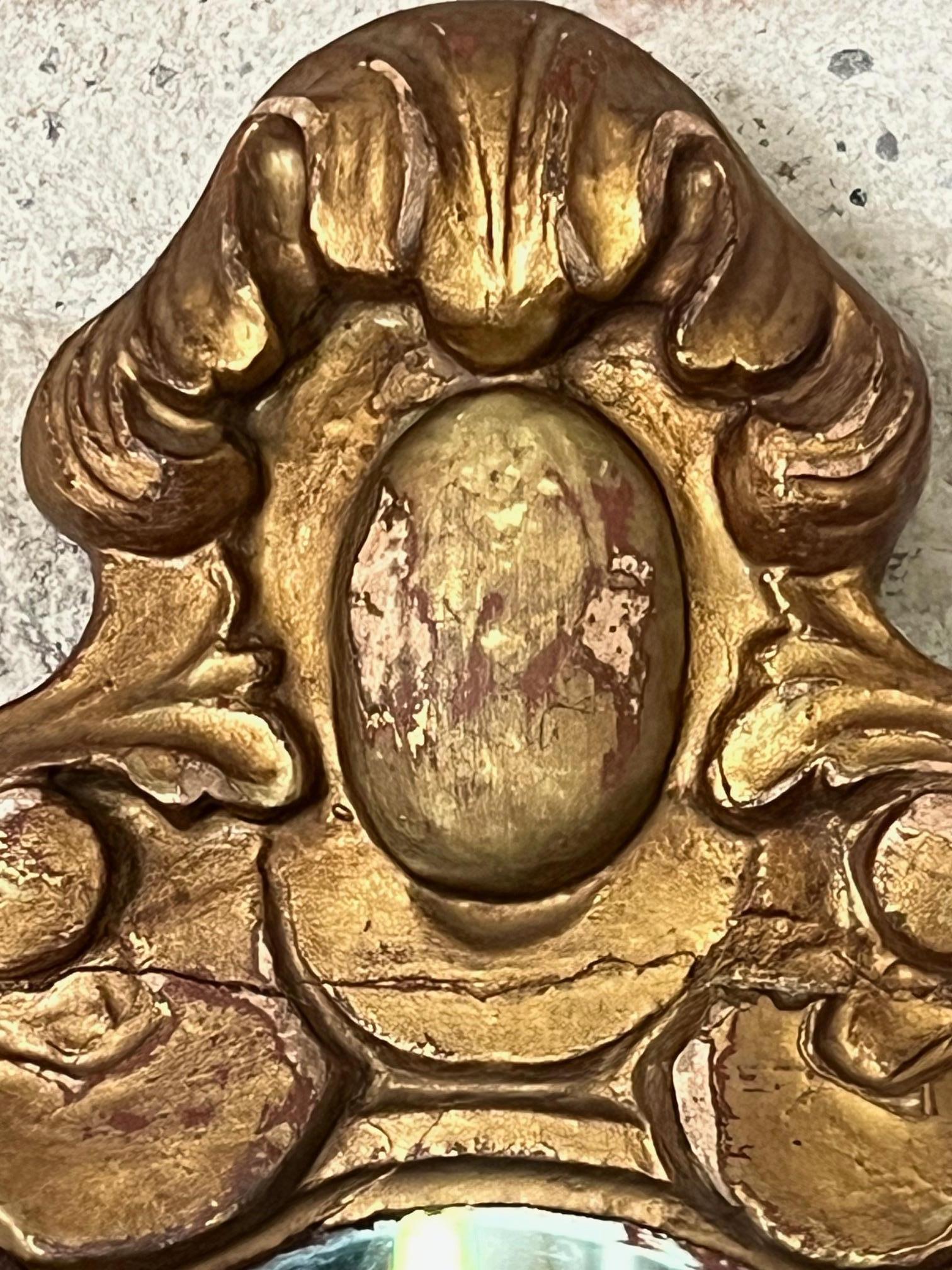 Specchio in quercia intagliato a mano realizzato in Francia tra la fine del 1700 e l'inizio del 1800. Il legno è dipinto in oro, il vetro non è originale ma antico e presenta alcuni segni di carattere.
