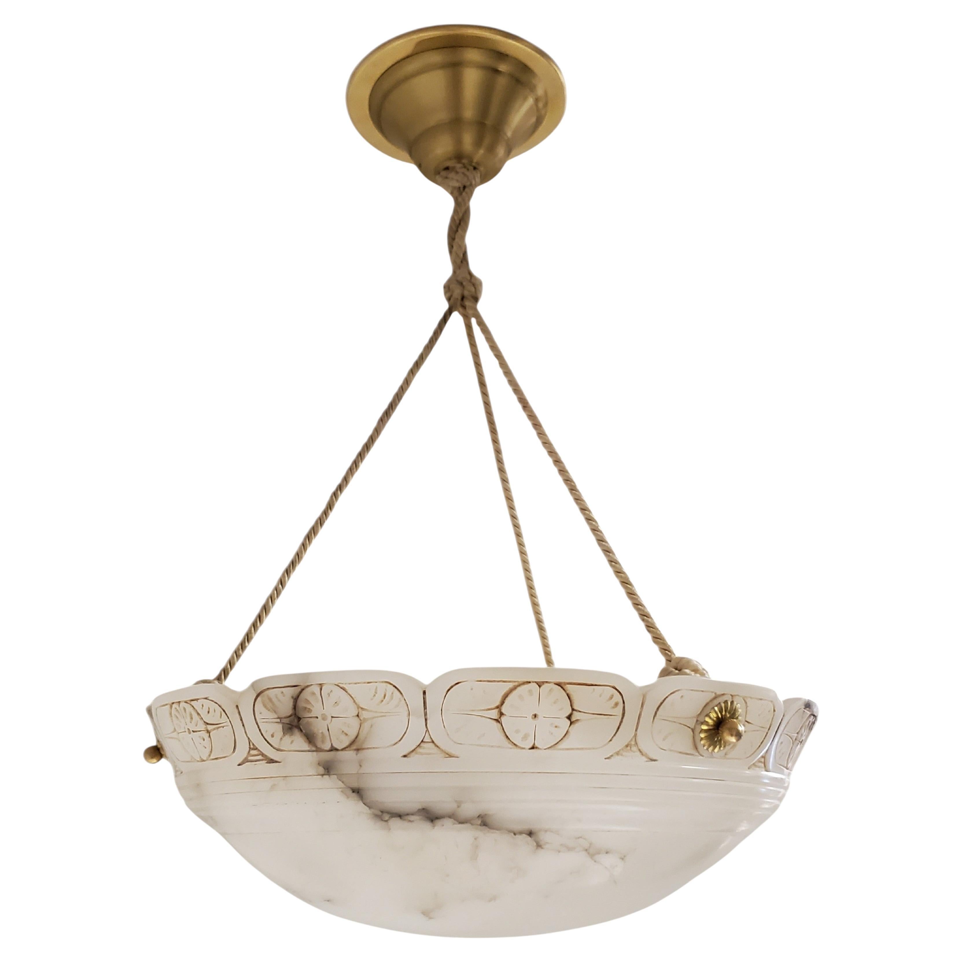 
An French Art Deco original hand carved off white alabaster bowl shape pendant chandelier with unusual scalopped edge featuring a few very subtle natural formations vis a vis wisps of contrasting gray natural veining, striations and translucent