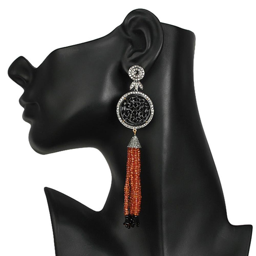 Hand Carved Onyx and Orange Sapphire Tassel Earring with Diamonds in Gold Silver is lovely and can be worn with any black dress and is very dramatic piece to add to your jewelry collection.


18kt gold: 2.11gms
Diamond: 4.6cts
Silver: